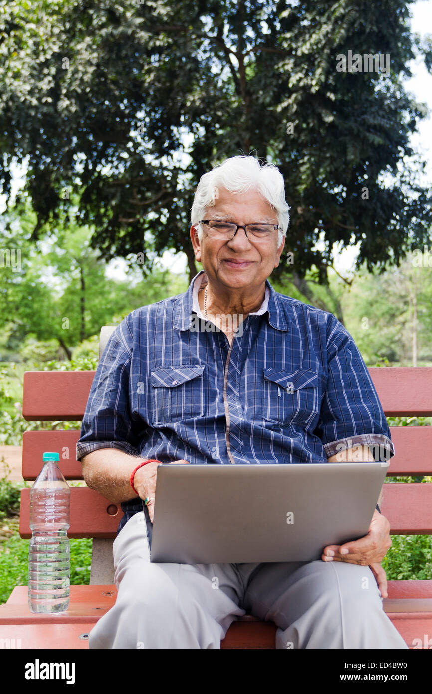 indische Greis Park Laptop arbeiten Stockfoto