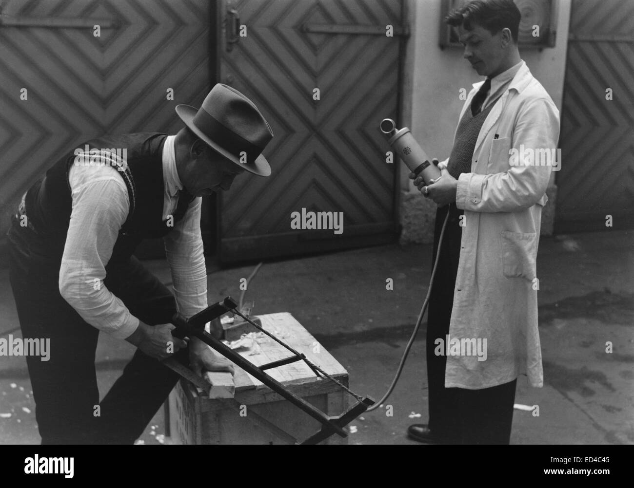 Ein historisches Foto aus den 1930er Jahren in Finnland, das einen Mann zeigt, der Soundeffekte aufnimmt. Das Bild zeigt eine frühe Ära der Tonaufzeichnungstechnologie, die im Rundfunk von Yle, dem nationalen öffentlich-rechtlichen Rundfunk Finnlands, eingesetzt wird. Stockfoto