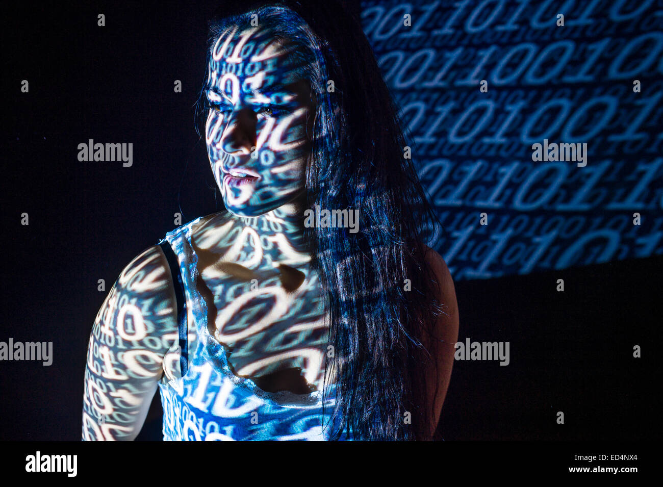 Digitale Kunst: Konzeptbild für Cyber-Terrorismus - eine junge Frau Mädchen verkleidet mit digitalen Bildmuster von binären Computer-Code auf ihr Gesicht projiziert. Stockfoto