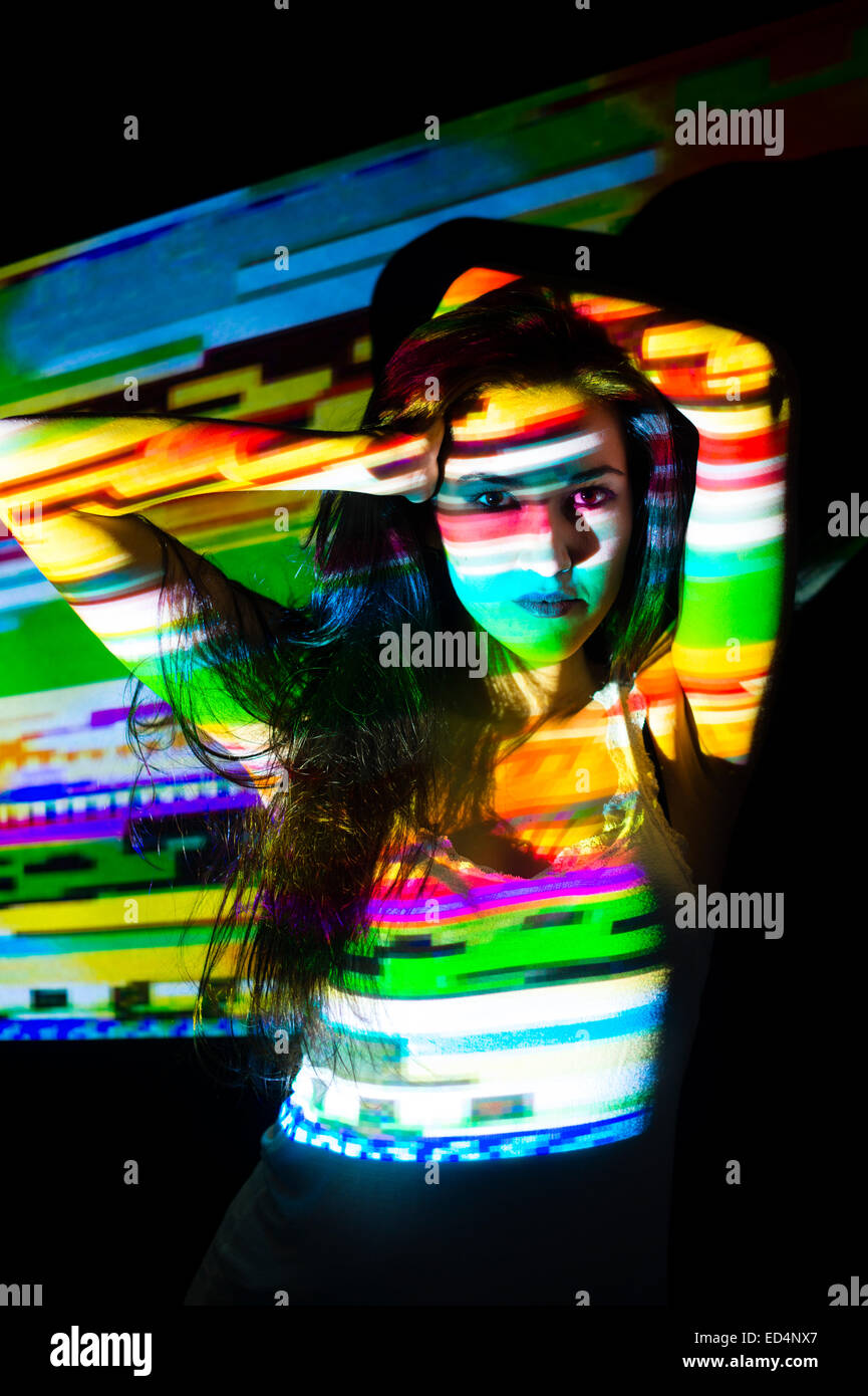 Digitale Kunst: eine junge Frau Mädchen mit bunten abstrakte digitale gestreiften gestreifte Bildmuster auf ihr Gesicht projiziert. Stockfoto