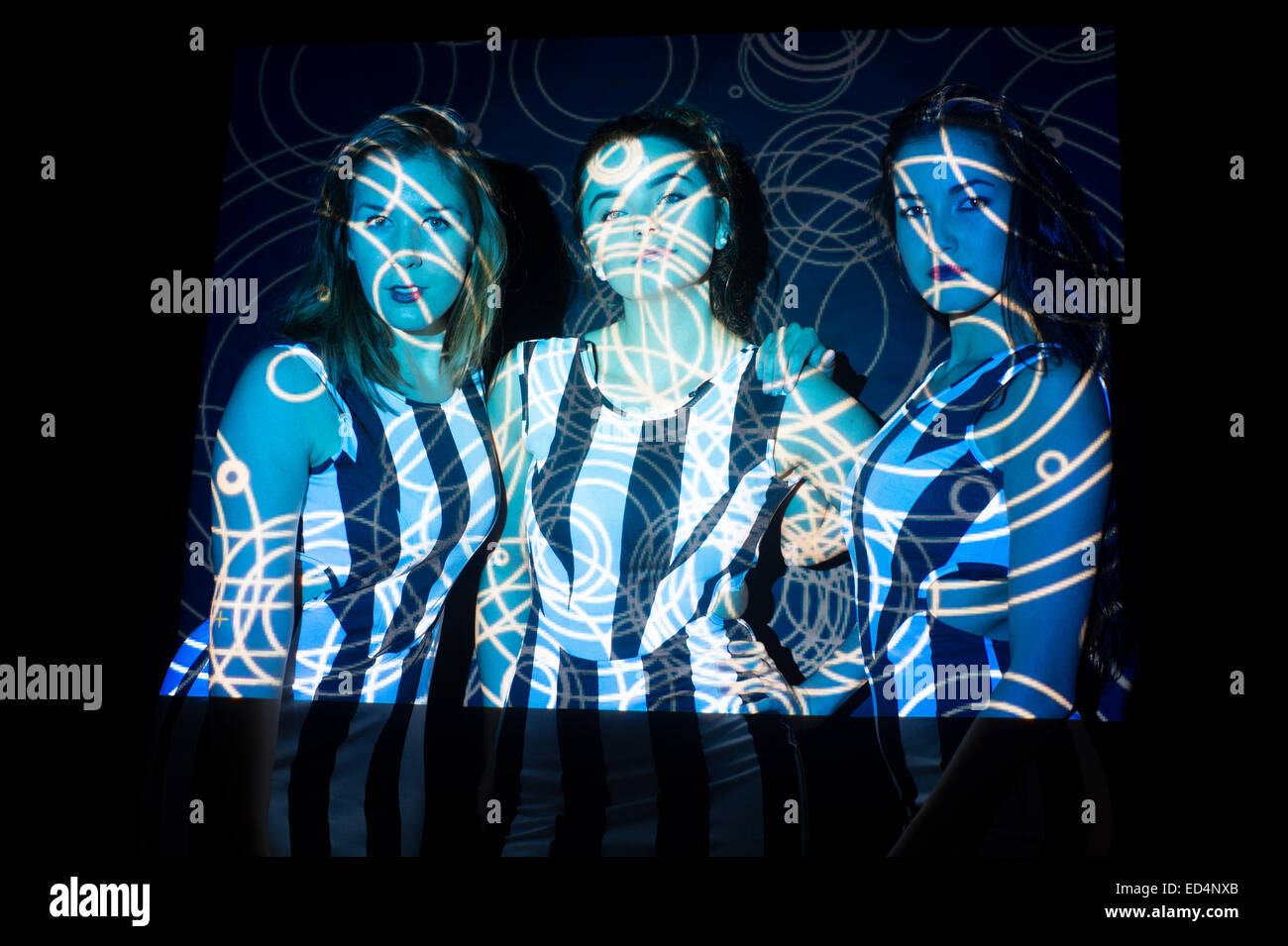 Digitale Kunst: drei junge Frauen Mädchen mit wirbelnden Digitalbild Spiralmuster auf ihren Gesichtern projiziert. Stockfoto