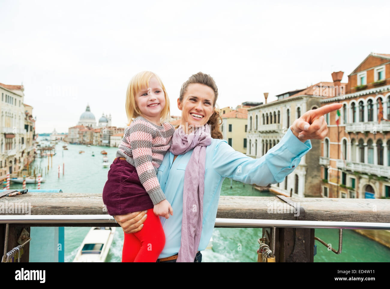 Baby Mädchen und Mutter deutete beim stehen auf der Brücke mit Blick auf Canale Grande in Venedig, Italien Stockfoto