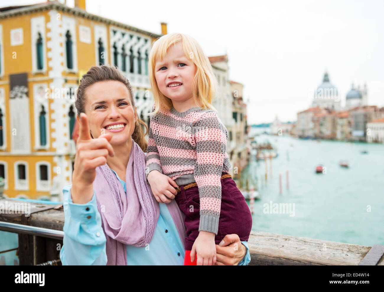 Baby Mädchen und Mutter deutete beim stehen auf der Brücke mit Blick auf Canale Grande in Venedig, Italien Stockfoto