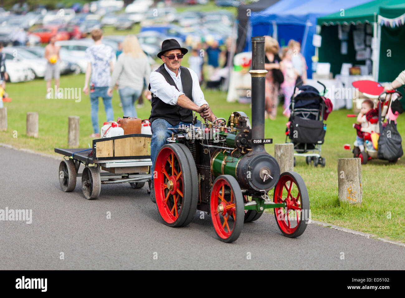 Mann fährt eine Miniatur Dampfmaschine Steam Rally in Pembrey Park, Carmarthenshire, Wales im Oktober 2014. Stockfoto