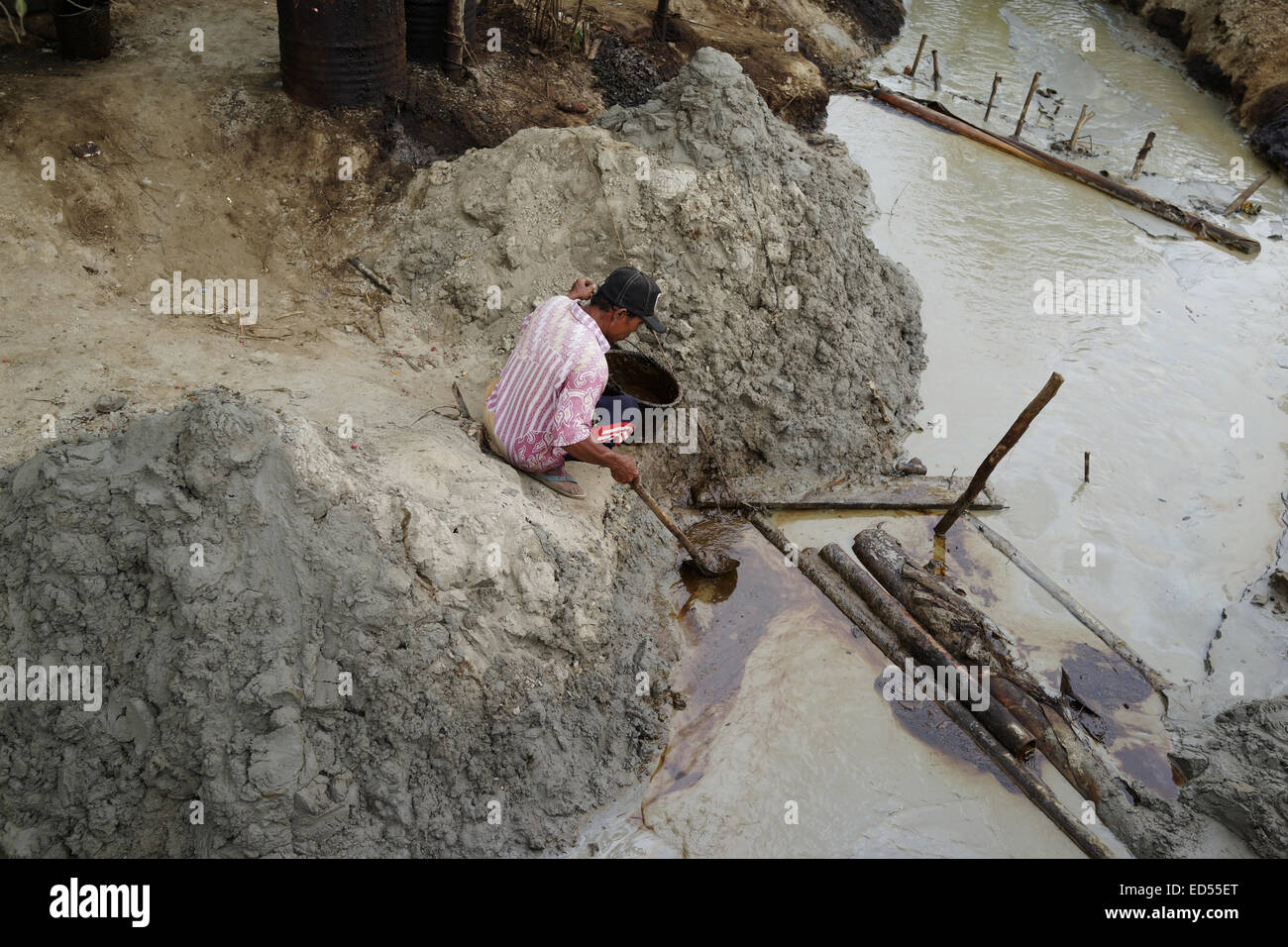 Ein Arbeiter sammelt Öl Reste der traditionellen Bergbau Entsorgung im Unterbezirk Kedewan, Bojonegoro, Indonesien Stockfoto