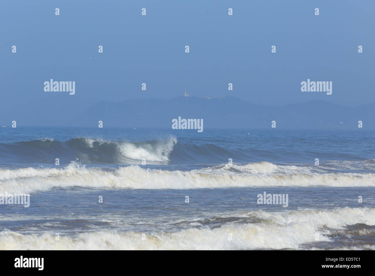 Ein Foto von entfernten Byron Bay in Australien von Brunswick Heads Strand genommen. Brechenden Wellen im Vordergrund zu sehen. Stockfoto