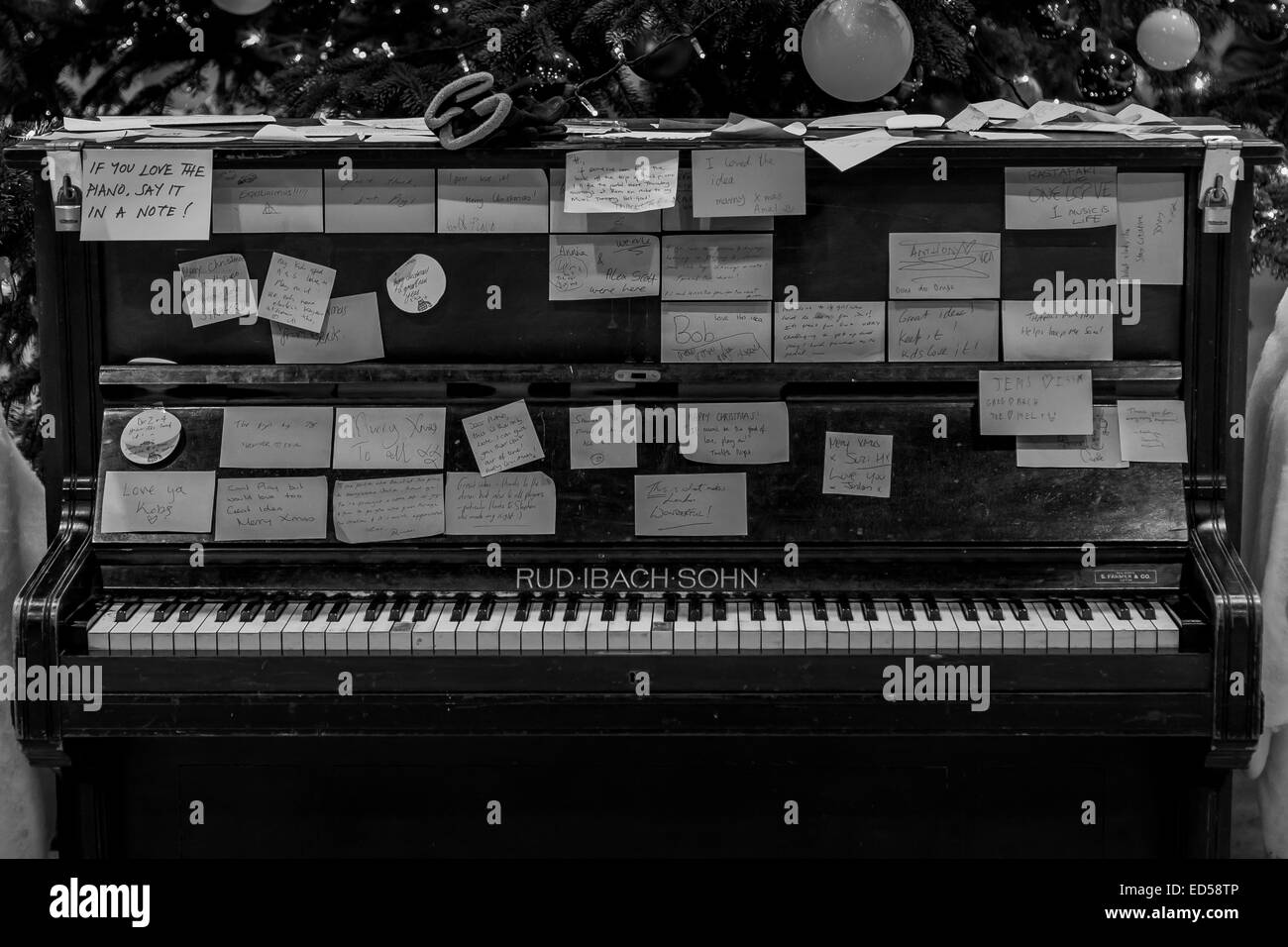 Ein Klavier links an einer Station für Menschen, Hinweise auf zu schreiben, für andere zu lesen, in Schwarzweiß gedreht Stockfoto