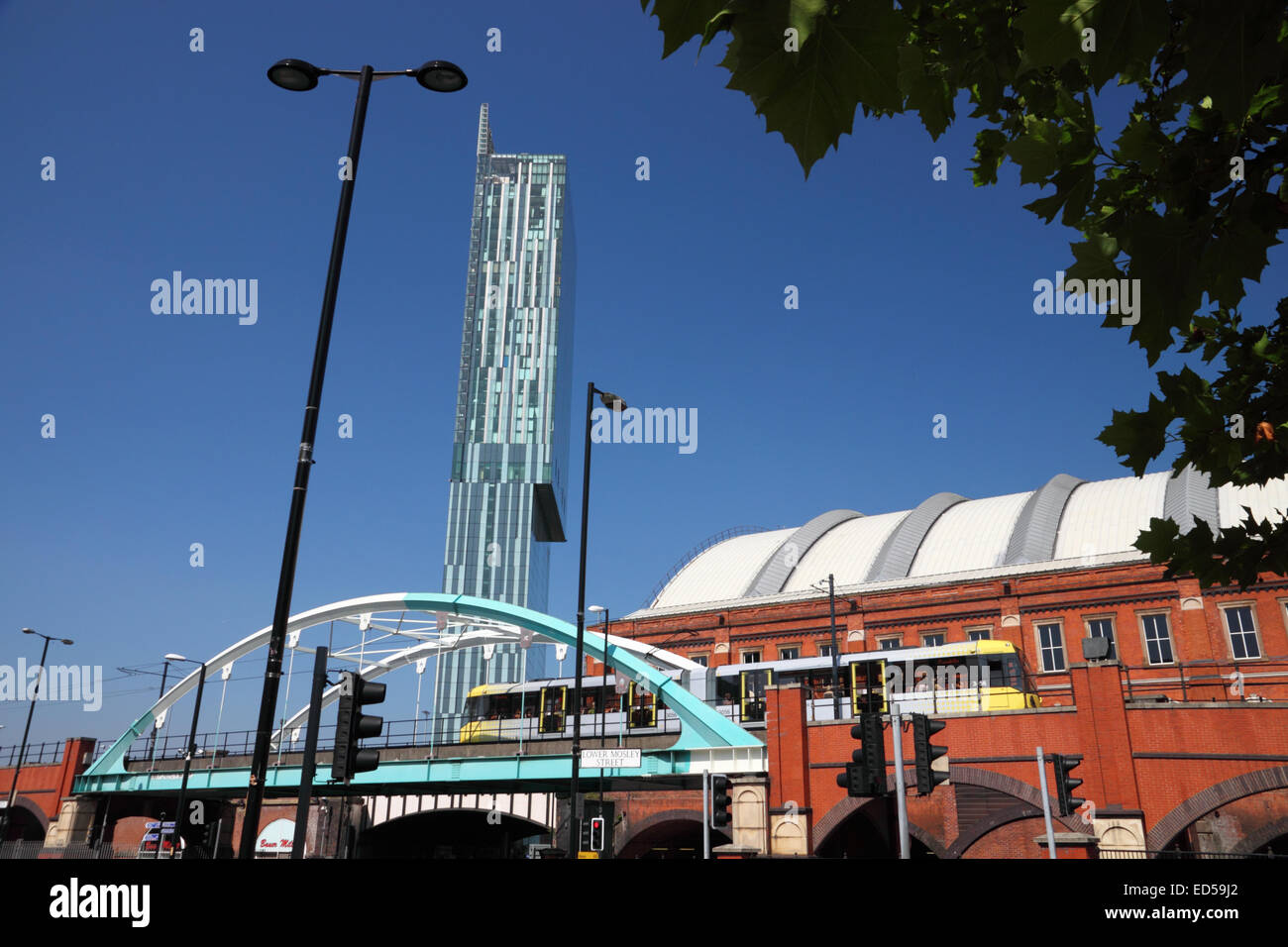 Eine gelbe Metro Link Straßenbahn große Bridgewater Street, Manchester eine eiserne Brücke überqueren. Stockfoto