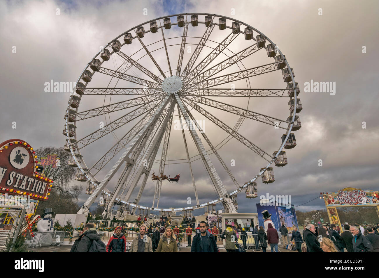LONDON HYDE PARK WINTER WONDERLAND EINE GASSE MENSCHEN UND EIN RIESENRAD MIT PASSAGIERKABINEN VOLLER Stockfoto