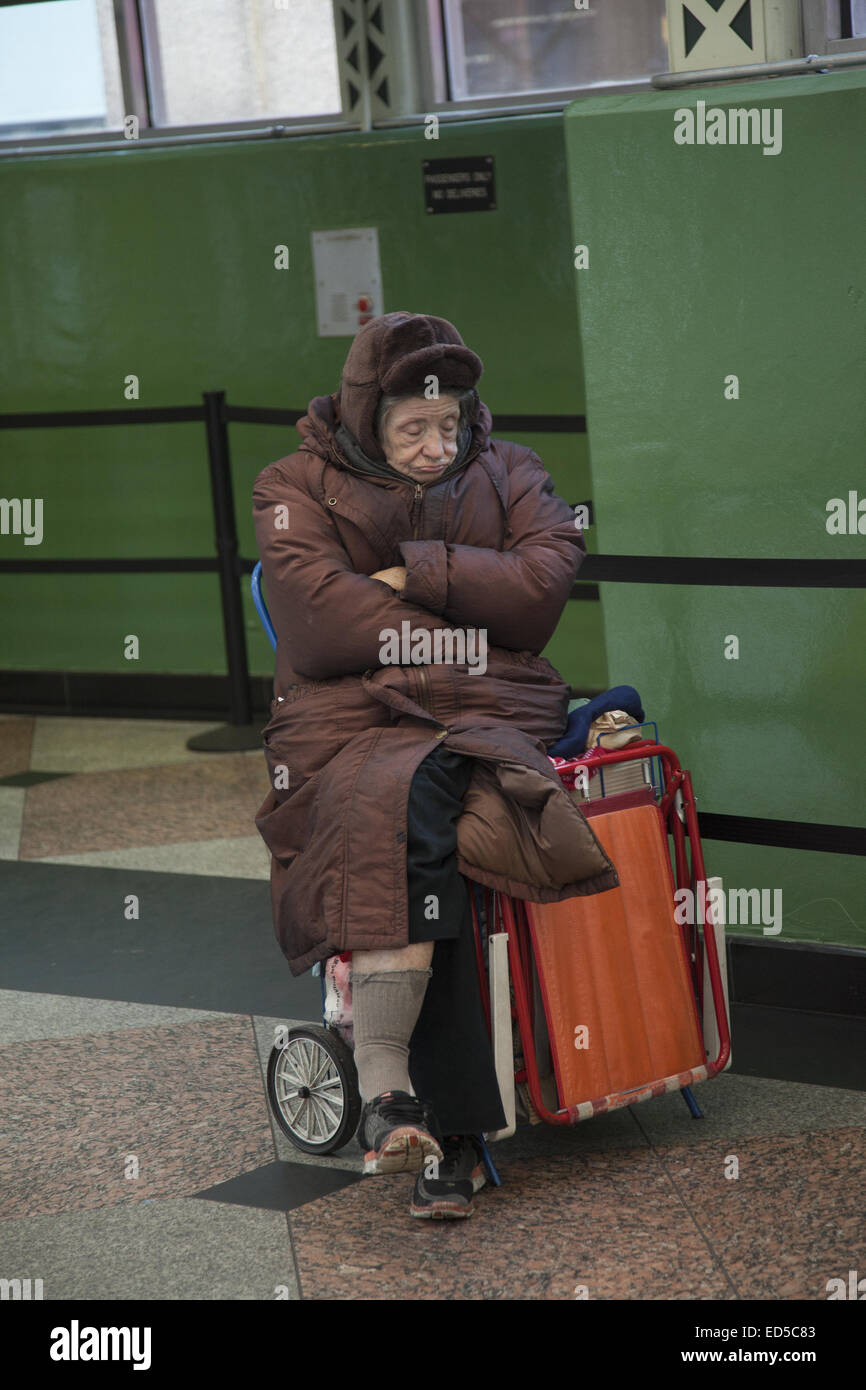Müde ältere obdachlose Frau in einer U-Bahn Station aus der Kälte. NYC. Stockfoto