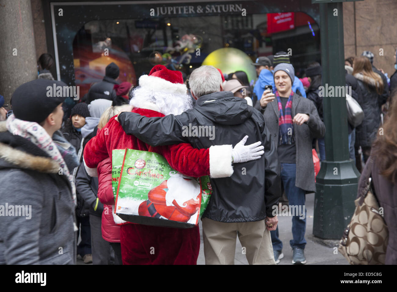 Mann nimmt Foto Freundin mit Santa Claus vor Macy's in New York City. Stockfoto