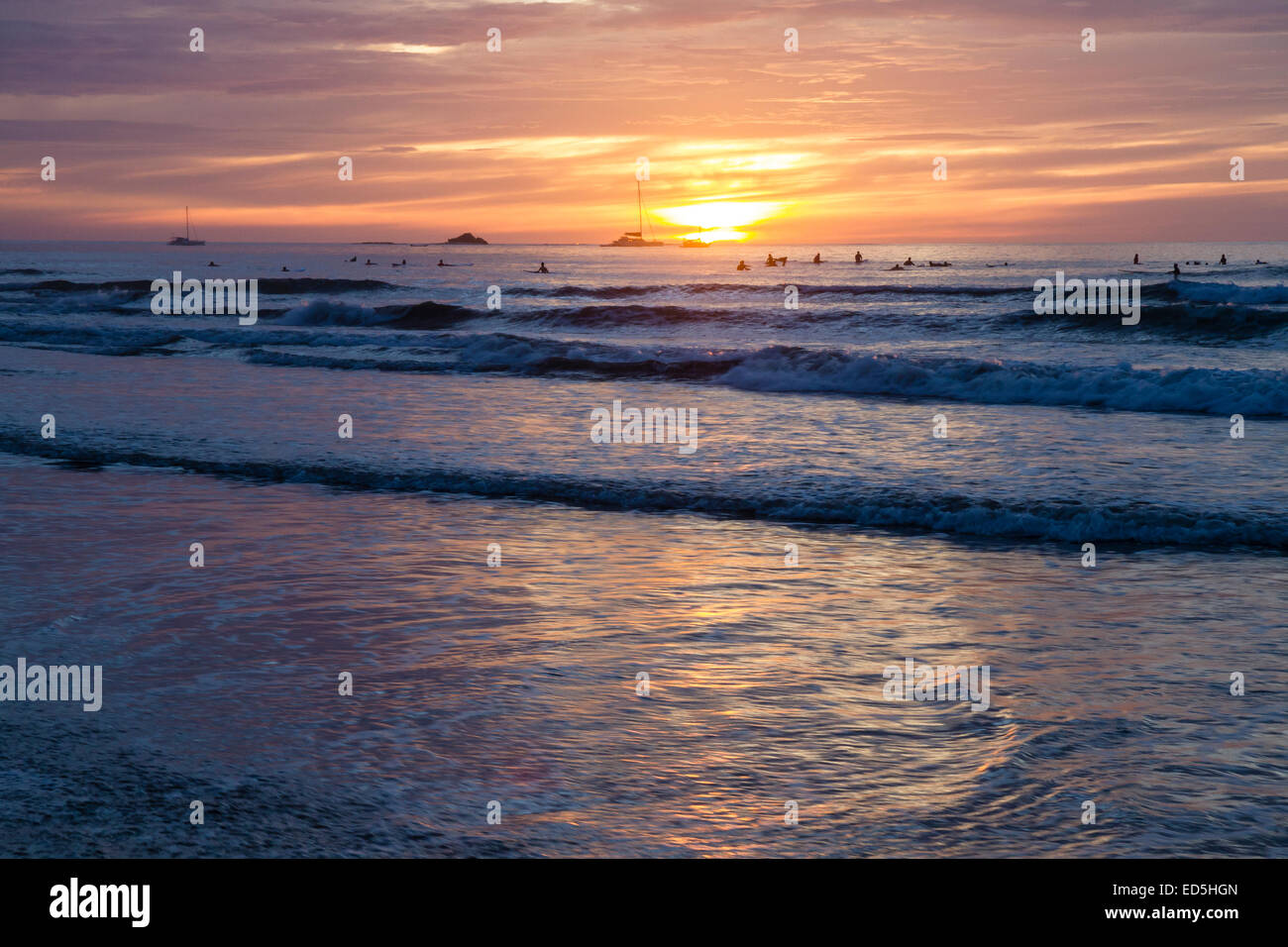 Surfer warten auf eine letzte Welle Silhouette gegen die untergehende Sonne am Playa Tamarindo, Guanacaste, Costa Rica Stockfoto
