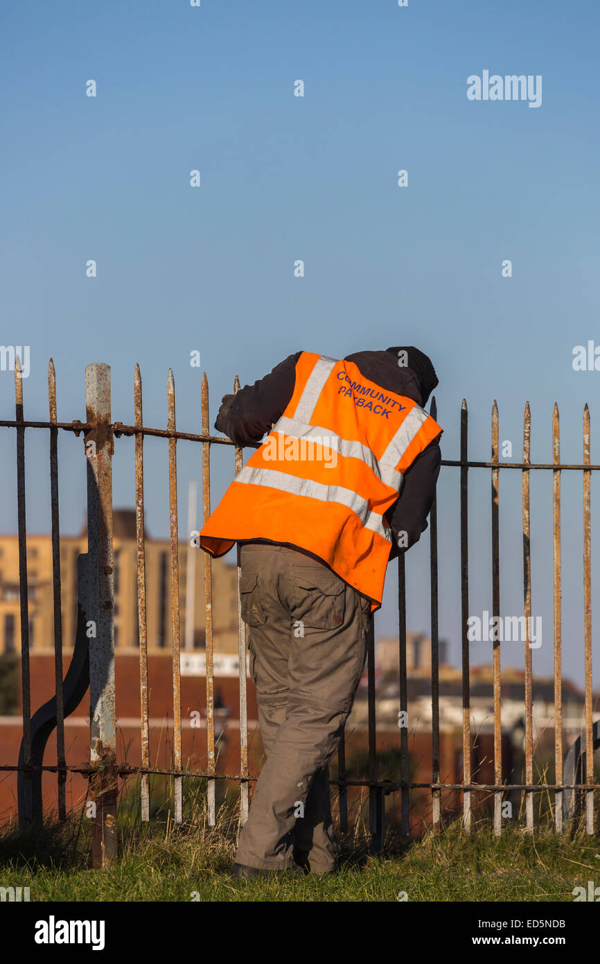 Täter in Southsea Castle, Portsmouth, Durchführung gemeinnütziger Arbeit; orangefarbene Jacke eingeschrieben "Gemeinschaft Payback" Stockfoto