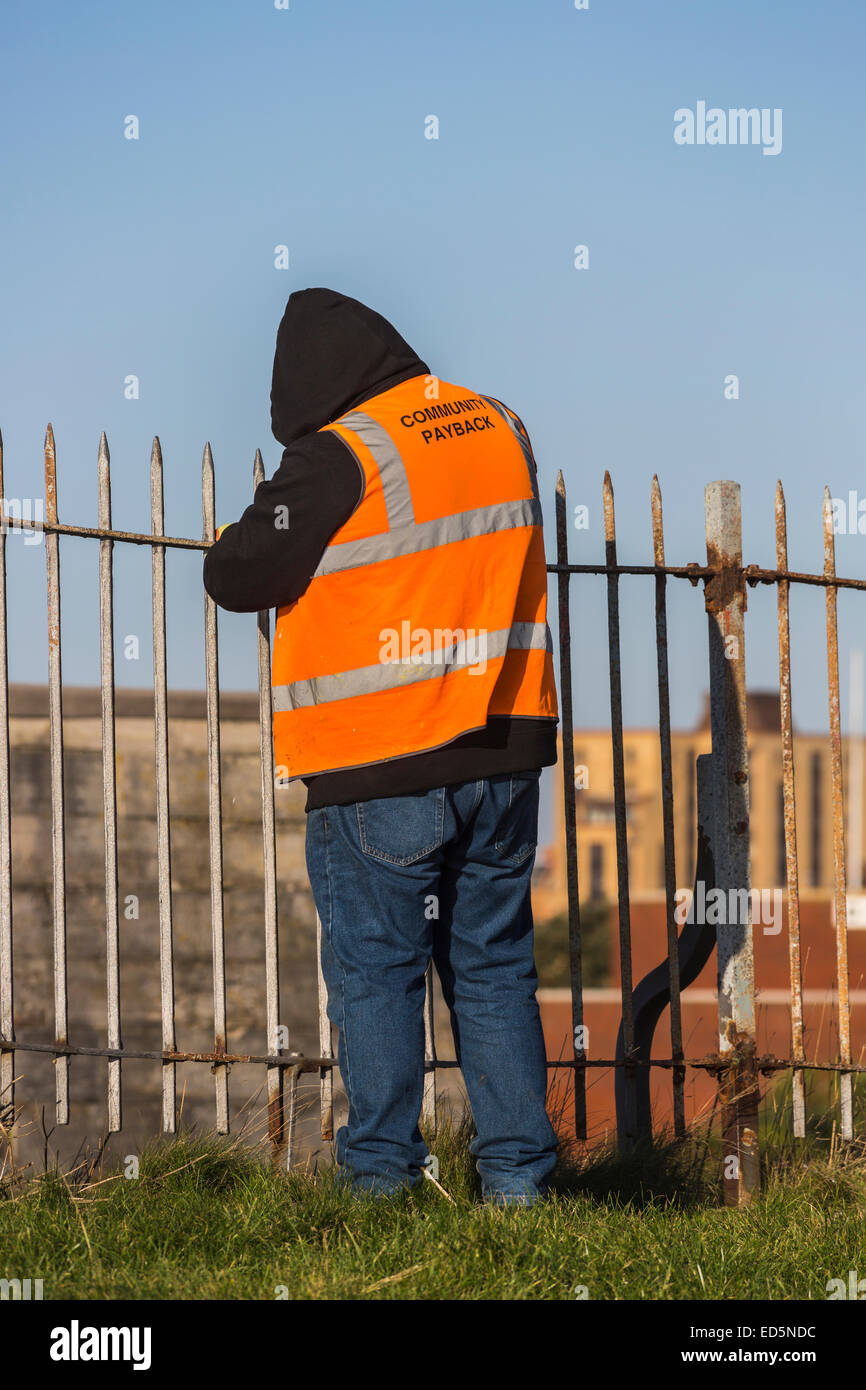 Strafvollzug: Straftäter, der in Southsea Castle, Portsmouth, arbeitet und Gemeindedienst durchführt; orangefarbene Jacke mit der Aufschrift "Community Payback" Stockfoto