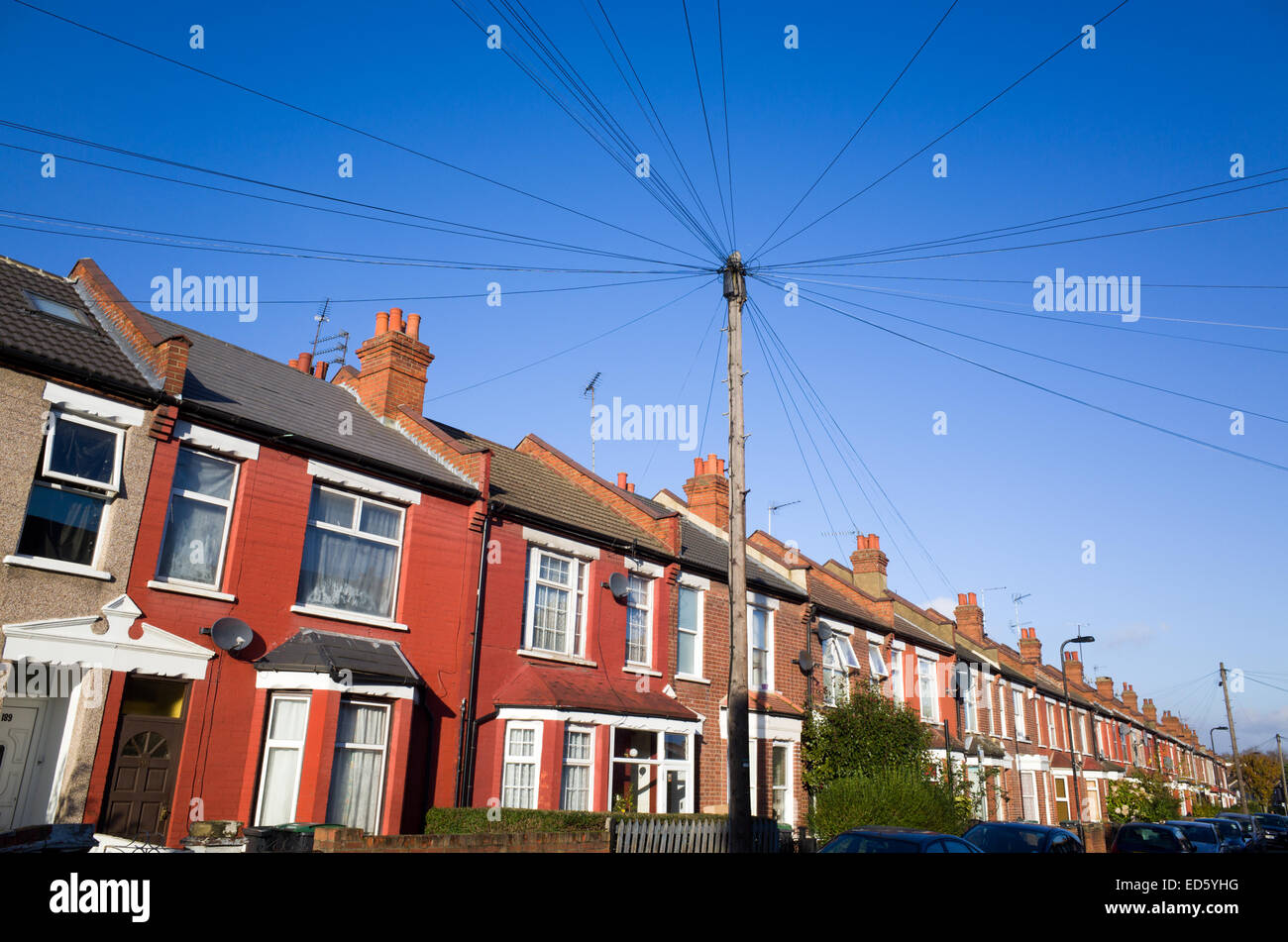 Telefonische Kommunikation Mast mit Drähten ausgeführt, die Reihenhäuser in Wohnstraße, Haringey, London, England, UK Stockfoto
