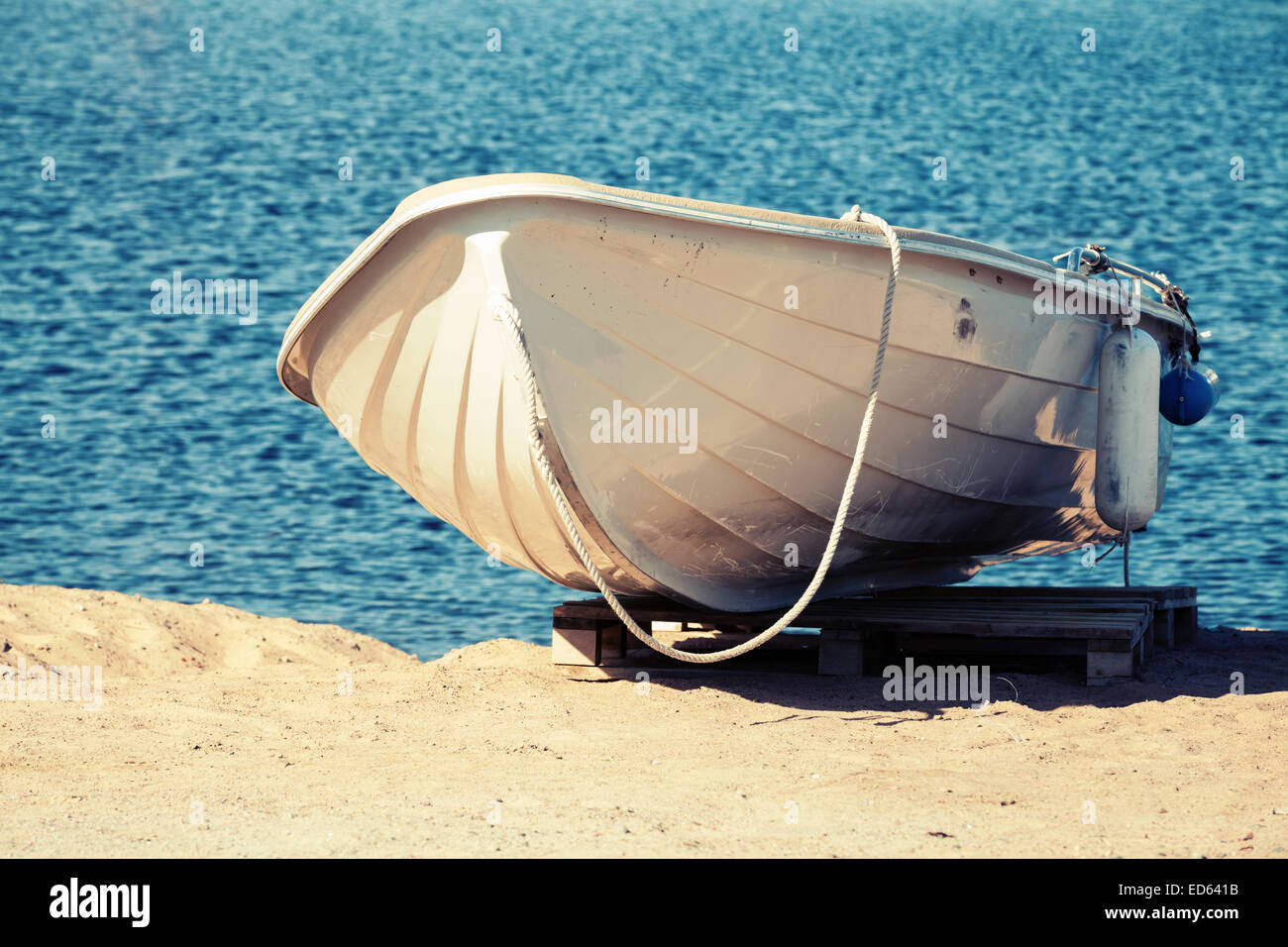 Weiße Ruderboot steht an der sandigen Küste. Vintage getönten Foto-Filter-Effekt Stockfoto