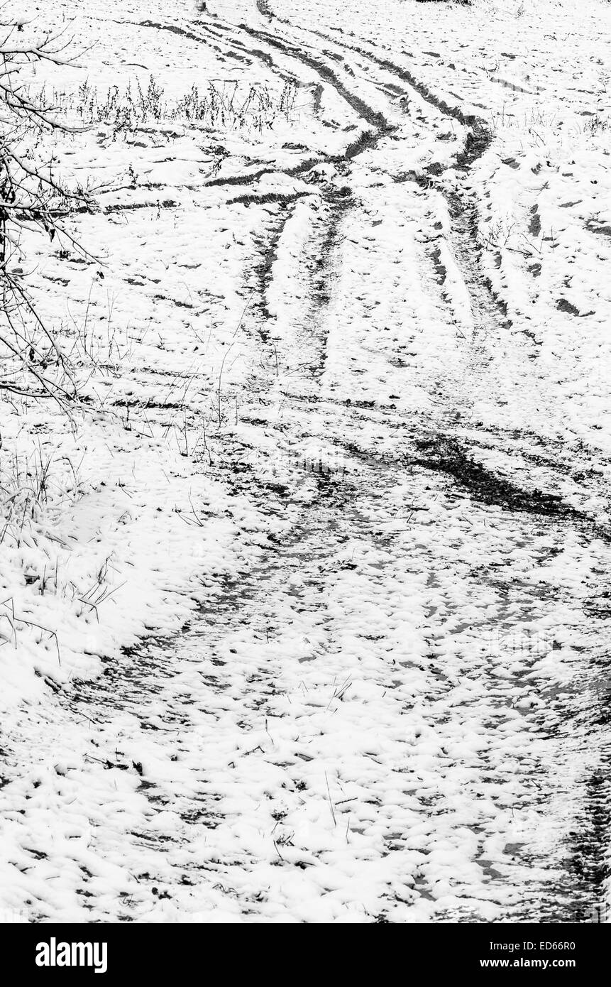 Reifenspuren auf Boden mit Schnee bedeckt Stockfoto