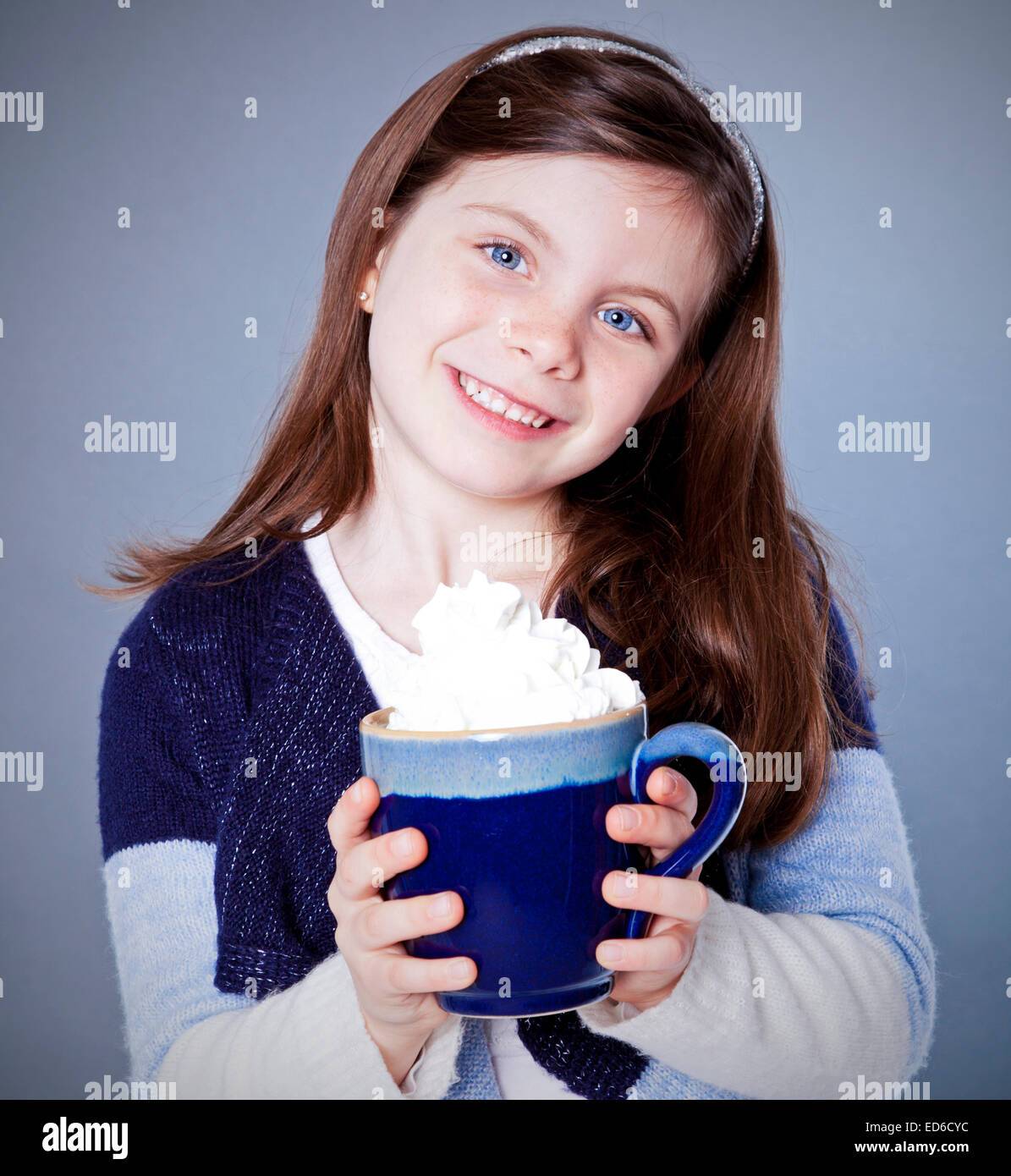 Hübsches Mädchen mit einer Tasse heißen Kakao auf grauem Hintergrund Stockfoto