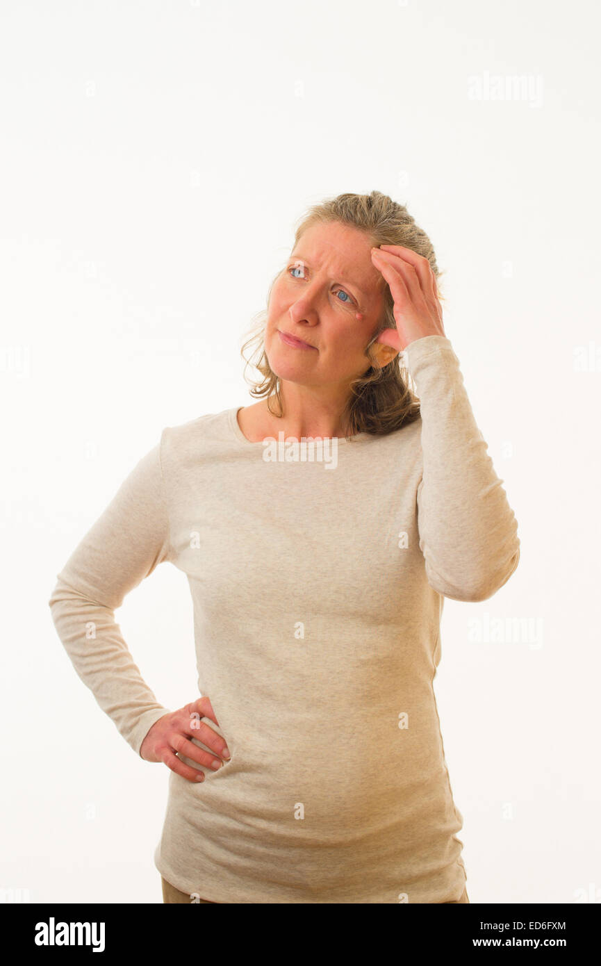 Eine verwirrt unsicher unsicher besorgt vierzig Jahre alten kaukasischen Frau kratzen den Kopf vor einem weißen Hintergrund. UK Stockfoto
