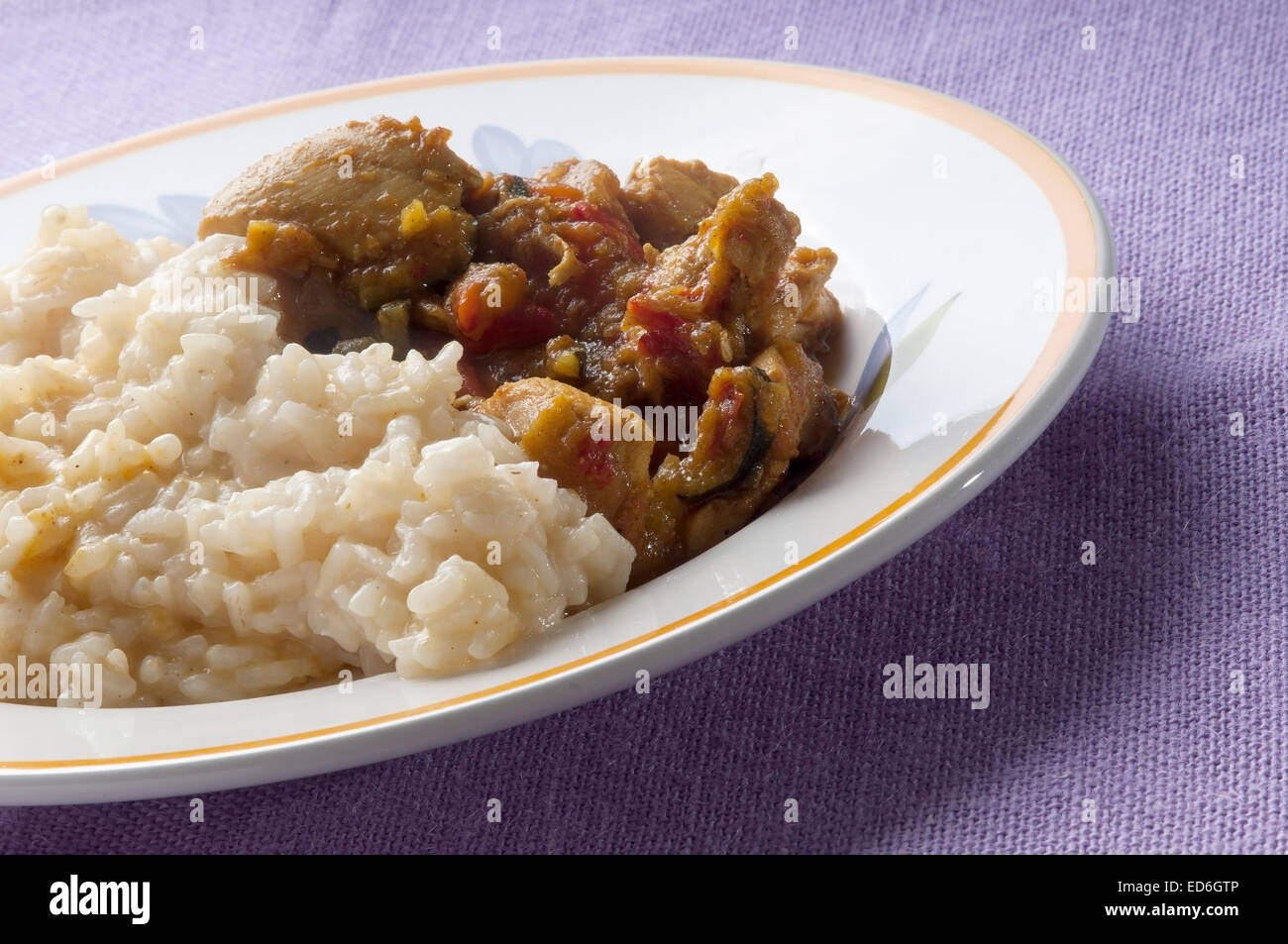 Hühnchen-Curry mit Gemüse und Reis Teller auf lila Tischdecke Stockfoto