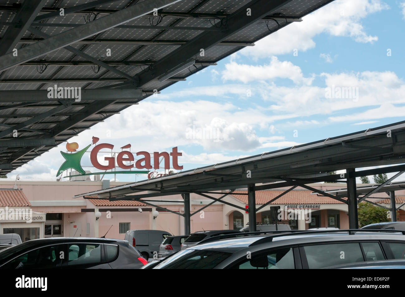 Autos unter Solar-Panels über den Parkplatz eines Supermarktes Französisch Geant Casino gebaut. Stockfoto