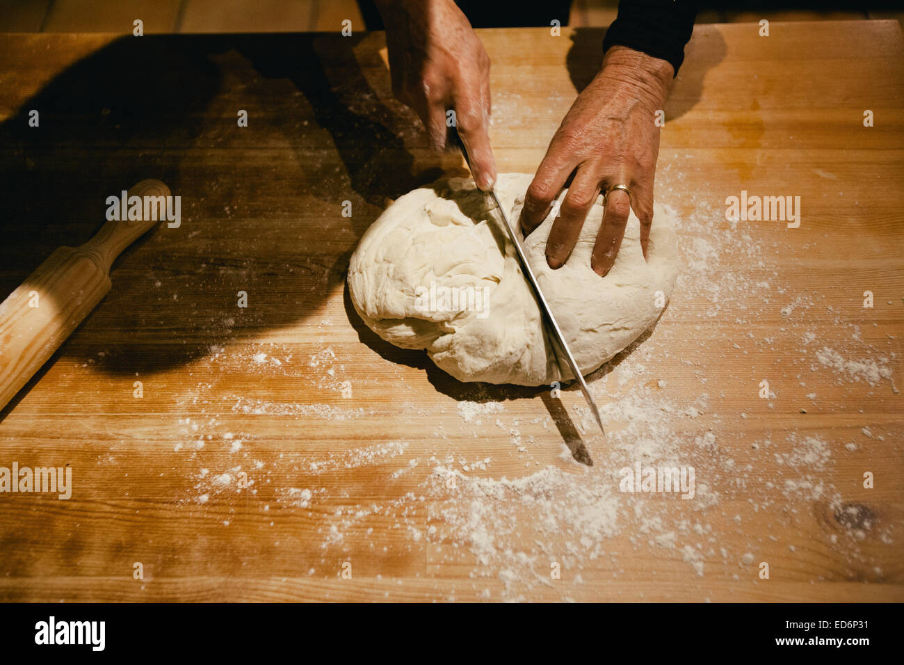 Händen kneten Weizen Brotteig auf einem Holztisch Stockfoto