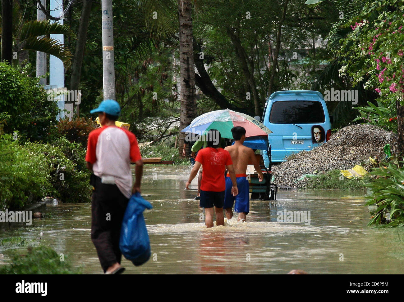 Cebu, Philippinen. 30. Dezember 2014. Bewohner Fuß in Flut von tropischer Sturm Jangmi in der Provinz Cebu, Philippinen, 30. Dezember 2014 gebracht. Mindestens sechs Menschen starben in Flut ausgelöst Vorfälle und ein anderer war angeblich fehlende als tropischer Sturm Jangmi (lokaler Name Seniang) zentrale-Philippinen, traf Regierungsquellen, sagte am Dienstag. Bildnachweis: Stringer/Xinhua/Alamy Live-Nachrichten Stockfoto