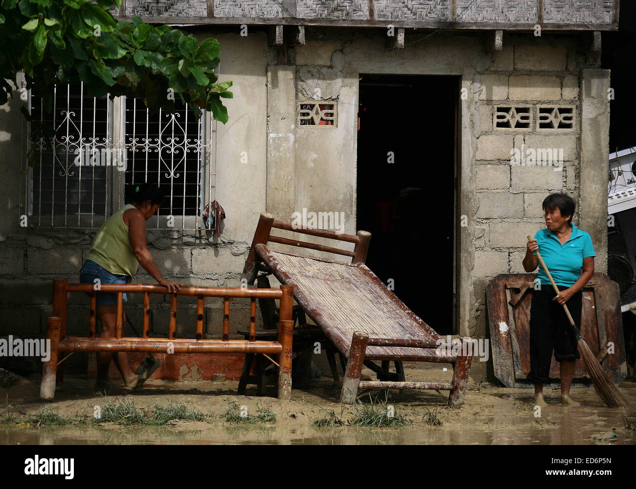Cebu, Philippinen. 30. Dezember 2014. Bewohner reinigen Sie ihr Haus von Schlamm nach einer Überschwemmung im Provinz Cebu, Philippinen, 30. Dezember 2014 tropischer Sturm Jangmi gebracht. Mindestens sechs Menschen starben in Flut ausgelöst Vorfälle und ein anderer war angeblich fehlende als tropischer Sturm Jangmi (lokaler Name Seniang) zentrale-Philippinen, traf Regierungsquellen, sagte am Dienstag. Bildnachweis: Stringer/Xinhua/Alamy Live-Nachrichten Stockfoto