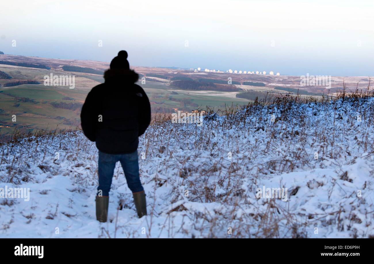 Mann auf verschneiten Spaziergang auf Ilkley Moor schaut RAF Menwith Hill Stockfoto