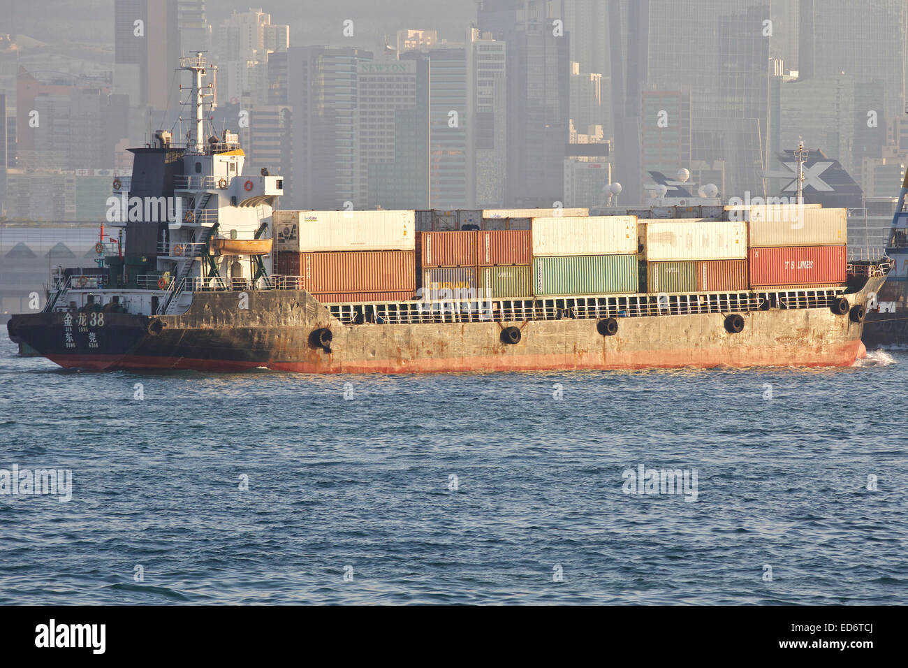 Kleine chinesische Containerschiff überquert die belebten Schifffahrtsweg In Kowloon Bay, Hong Kong. Stockfoto