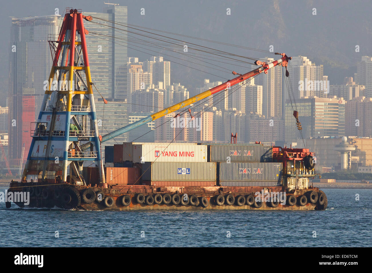 Voll beladen Derrick Barge beladen mit Container, unter Tow In Victoria Harbour und Hong Kong. Stockfoto