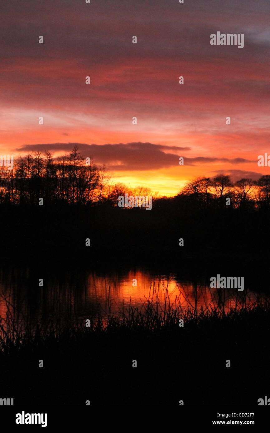 Winter-Sonnenwende Sonnenuntergang spiegelt sich im Wasser am Lakeside Country Park, Eastleigh, Hampshire, England, UK Stockfoto