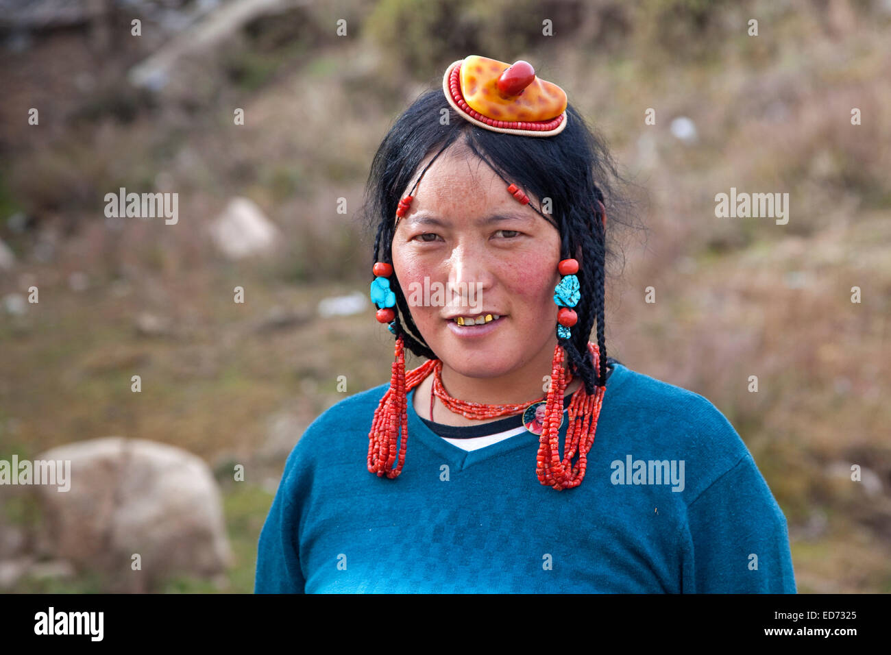 Porträt des tibetischen Khampa Frau trägt Schmuck, traditionelle gelb und rot Korallen Haarteil in Zhuqing, Provinz Sichuan, China Stockfoto