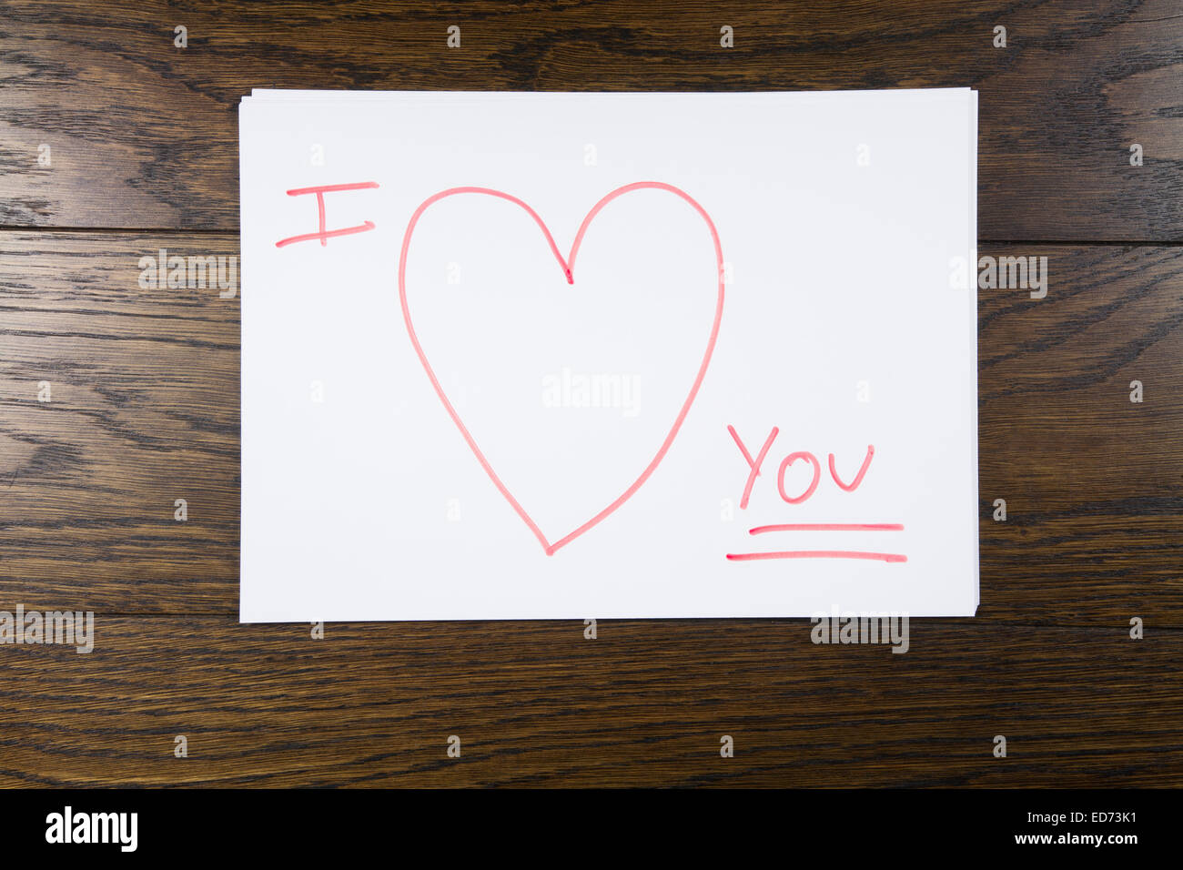 Ich liebe dich Text geschrieben mit orange Markierung auf weißem Papier über Braun Holz Hintergrund Stockfoto