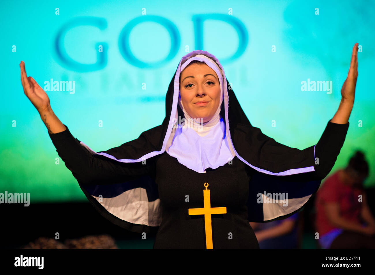 Aberystwyth University Bachelor Grad Studien (TFTS) Theaterstudenten Durchführung Caryls "Liebe und Informationen", gekleidet UK - eine Frau-Mädchen als Nonne mit ihren Armen in Anbetung erhoben Stockfoto