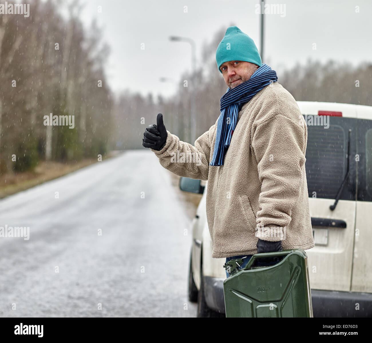 Das Fahrzeug hat auf der Straße, männlichen versuchen Daumen eine Fahrt Treibstoff ausgehen. Stockfoto
