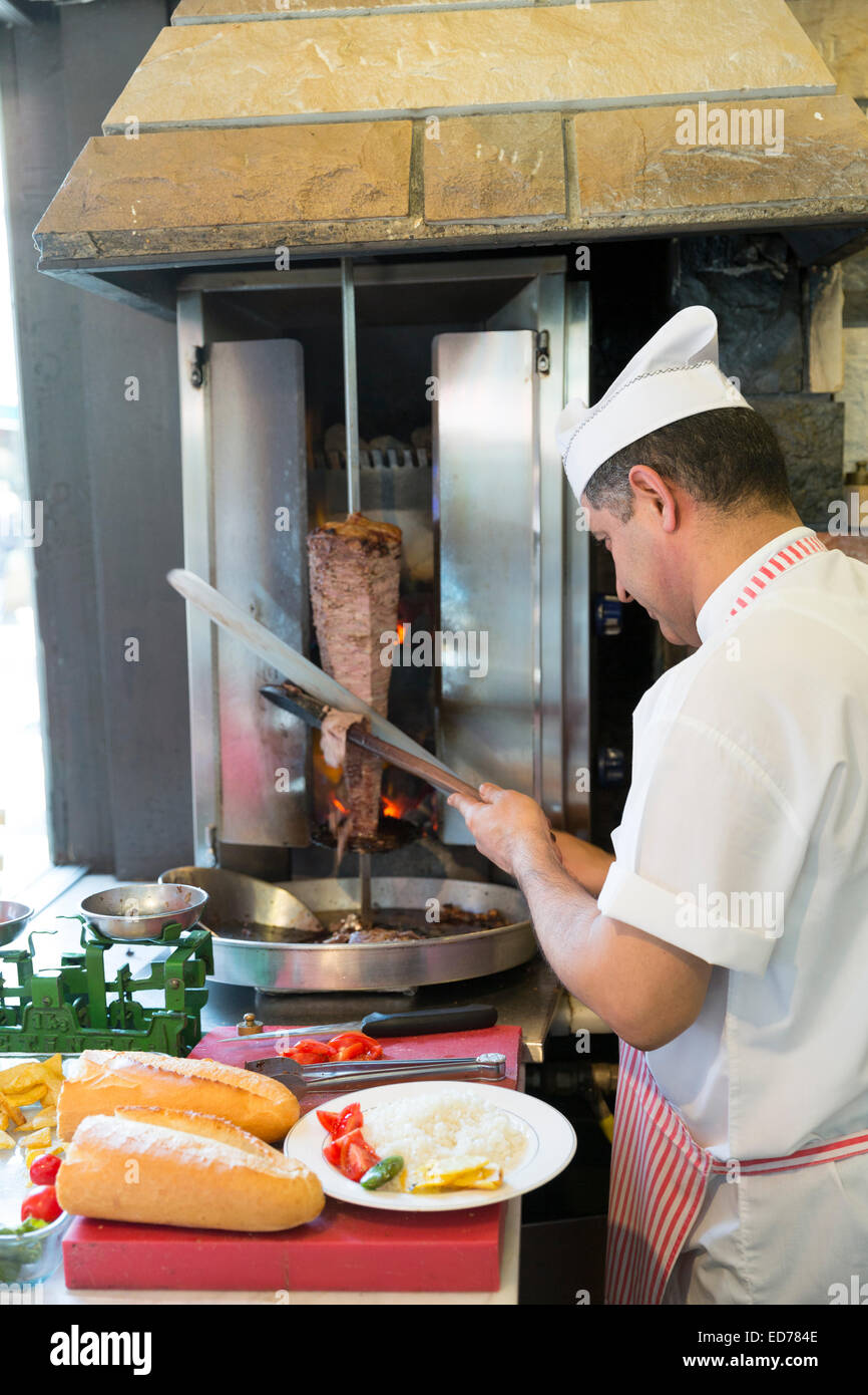 Küchenchef im türkischen Restaurant Ciya Sofrasi schneiden Lamm döner Kebab in Kadiköy Bezirk asiatische Seite von Istanbul, Ost-Türkei Stockfoto