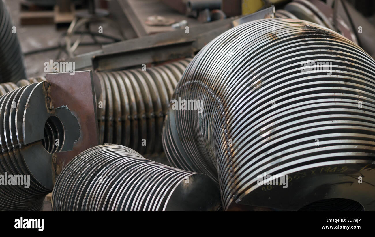 Stahlteile für Förderschnecken in einem frühen Stadium der Produktion. Geringe Schärfentiefe. Stockfoto