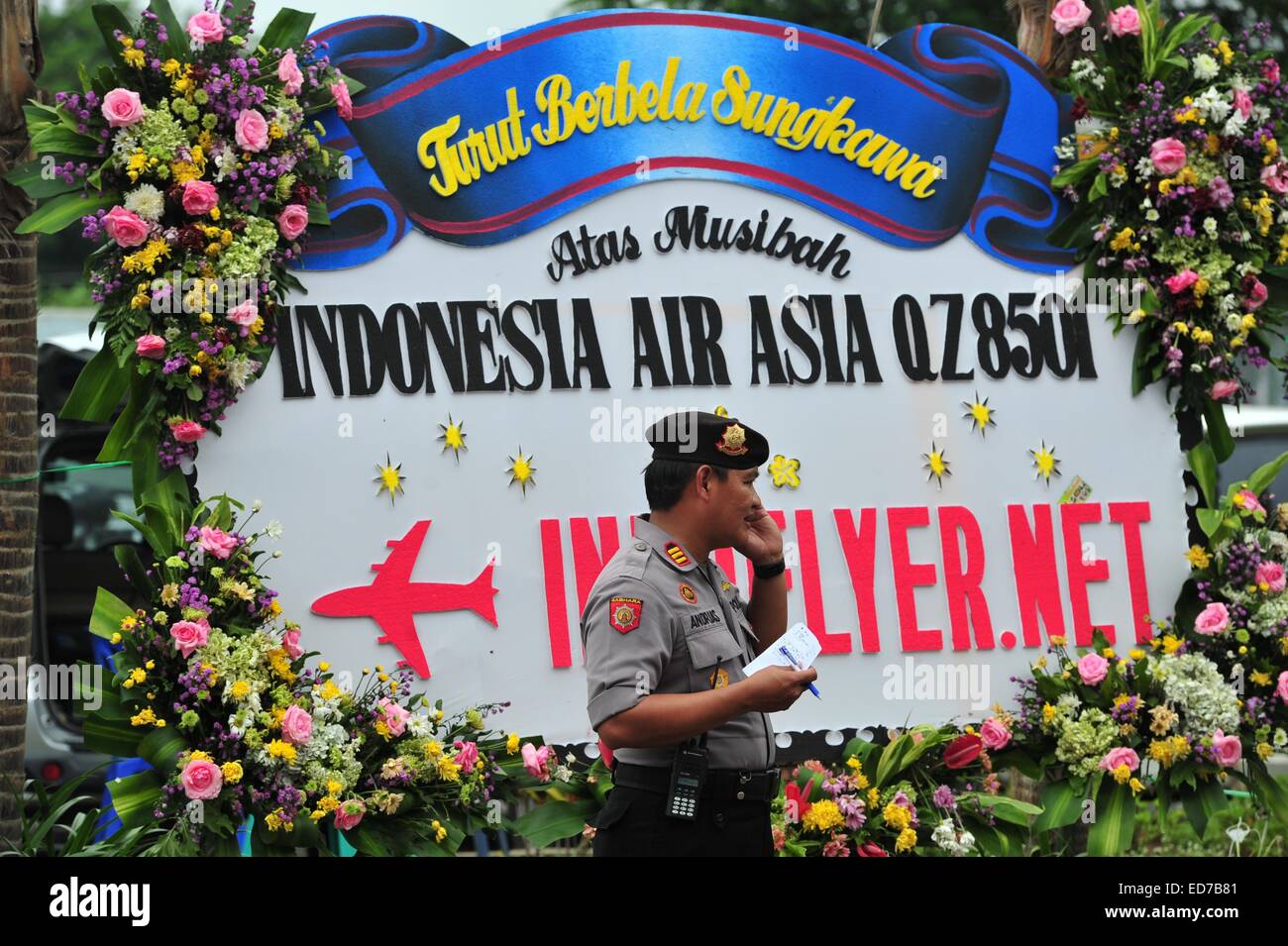 Jakarta, Indonesien. 31. Dezember 2014. Ein indonesische Polizisten geht vorbei an Kondolenzschreiben Zeichen für Menschen auf Indonesia AirAsia Flug QZ8501 Juanda International Airport in Surabaya, Indonesien, 31. Dezember 2014. Indonesische Retter auf der Suche nach dem fehlenden AirAsia Flugzeug haben sechs Leichen entdeckt und drei aus den Gewässern vor der südlichen Küste von Kalimantan Insel erholt, kurz nachdem sie Treibgut später bestätigt, dass aus dem ill-fated Flugzeug beobachtet. Bildnachweis: Zulkarnain/Xinhua/Alamy Live-Nachrichten Stockfoto