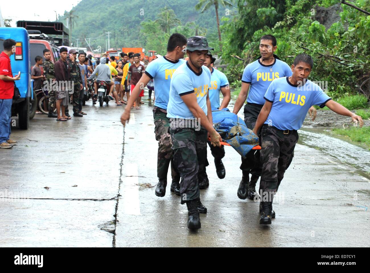 Mindanao, Philippinen. 30. Dezember 2014. Polizisten erholt Leichen von Erdrutsch Opfer. Der Sturm, als Seniang auf den Philippinen und Jangmi International bekannt, als eine Depression Samstag östlich von Mindanao, südliche Hauptinsel des Landes entwickelt. Berichten zufolge 31 Menschen sind tot, 10 fehlen, Tausende wurden evakuiert und Standred Reisenden als es driftet nach Westen durch die Philippinen Entfesselung Ströme von Regen, die tödliche Erdrutsche und Überschwemmungen geführt haben. Bildnachweis: Pazifische Presse/Alamy Live-Nachrichten Stockfoto