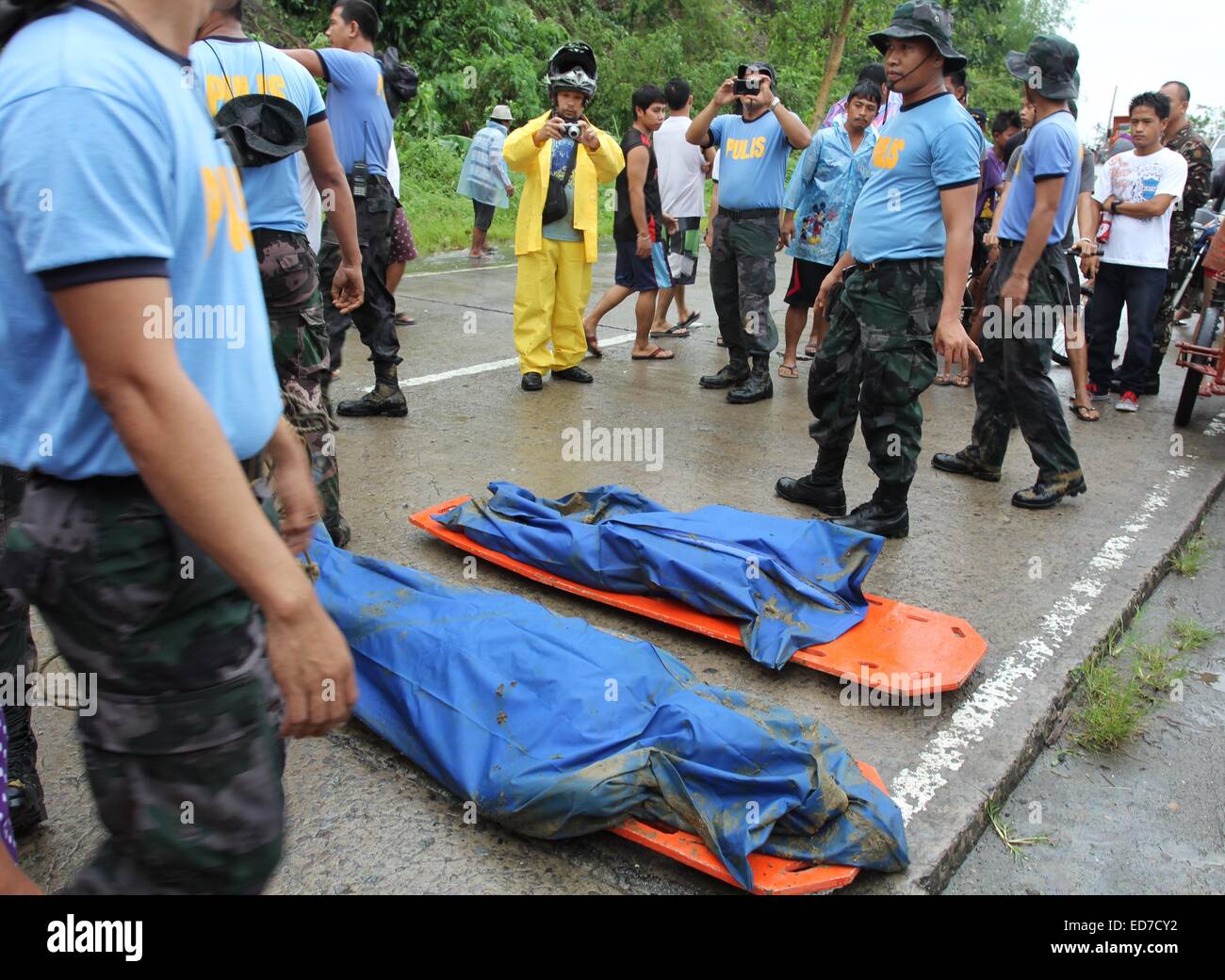 Mindanao, Philippinen. 30. Dezember 2014. Polizisten erholt Leichen von Erdrutsch Opfer. Der Sturm, als Seniang auf den Philippinen und Jangmi International bekannt, als eine Depression Samstag östlich von Mindanao, südliche Hauptinsel des Landes entwickelt. Berichten zufolge 31 Menschen sind tot, 10 fehlen, Tausende wurden evakuiert und Standred Reisenden als es driftet nach Westen durch die Philippinen Entfesselung Ströme von Regen, die tödliche Erdrutsche und Überschwemmungen geführt haben. Bildnachweis: Pazifische Presse/Alamy Live-Nachrichten Stockfoto