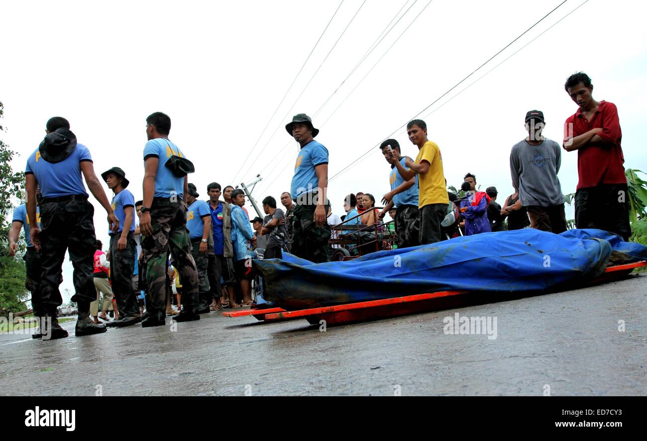 Mindanao, Philippinen. 30. Dezember 2014. Polizisten erholt Leichen von Erdrutsch Opfer. Der Sturm, als Seniang auf den Philippinen und Jangmi International bekannt, als eine Depression Samstag östlich von Mindanao, südliche Hauptinsel des Landes entwickelt. Berichten zufolge 31 Menschen sind tot, 10 fehlen, Tausende wurden evakuiert und Standred Reisenden als es driftet nach Westen durch die Philippinen Entfesselung Ströme von Regen, die tödliche Erdrutsche und Überschwemmungen geführt haben. Bildnachweis: Pazifische Presse/Alamy Live-Nachrichten Stockfoto