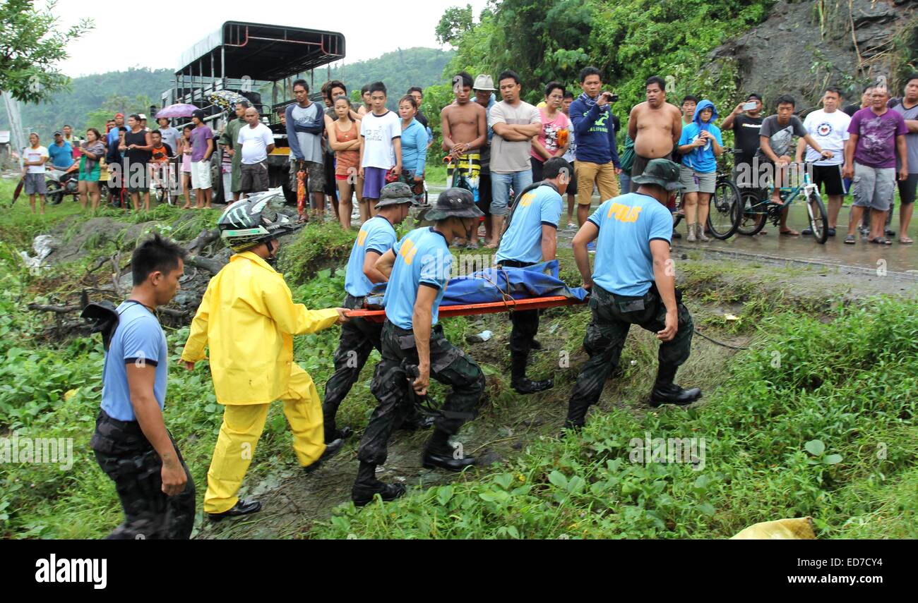 Mindanao, Philippinen. 30. Dezember 2014. Polizisten erholt Leichen von Erdrutsch Opfer. Der Sturm, als Seniang auf den Philippinen und Jangmi International bekannt, als eine Depression Samstag östlich von Mindanao, südliche Hauptinsel des Landes entwickelt. Berichten zufolge 31 Menschen sind tot, 10 fehlen, Tausende wurden evakuiert und Standred Reisenden als es driftet nach Westen durch die Philippinen Entfesselung Ströme von Regen, die tödliche Erdrutsche und Überschwemmungen geführt haben. Bildnachweis: Pazifische Presse/Alamy Live-Nachrichten Stockfoto