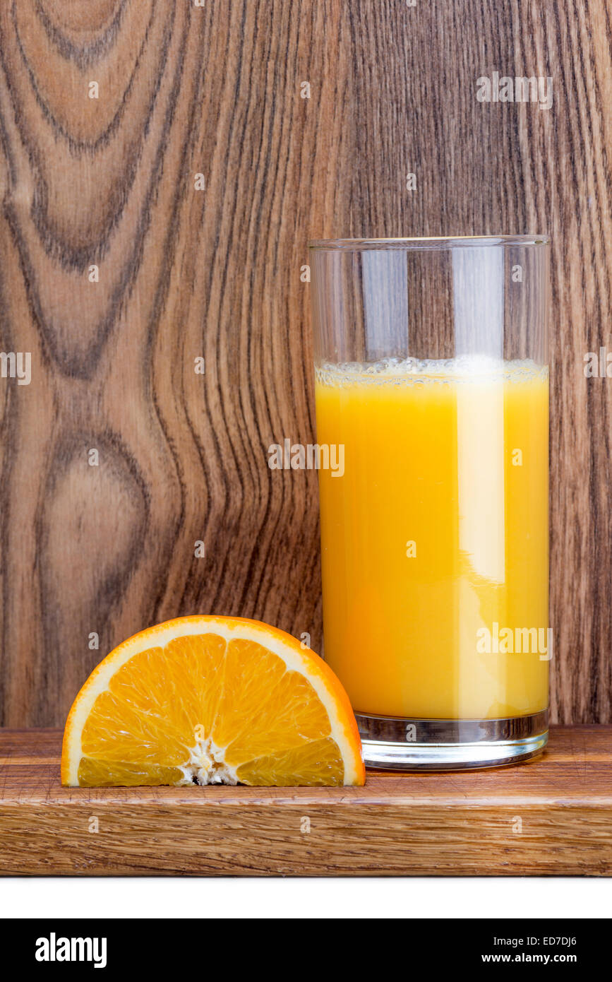 Orangenscheibe und einem Glas Orangensaft auf einem dunklen Holztisch Stockfoto