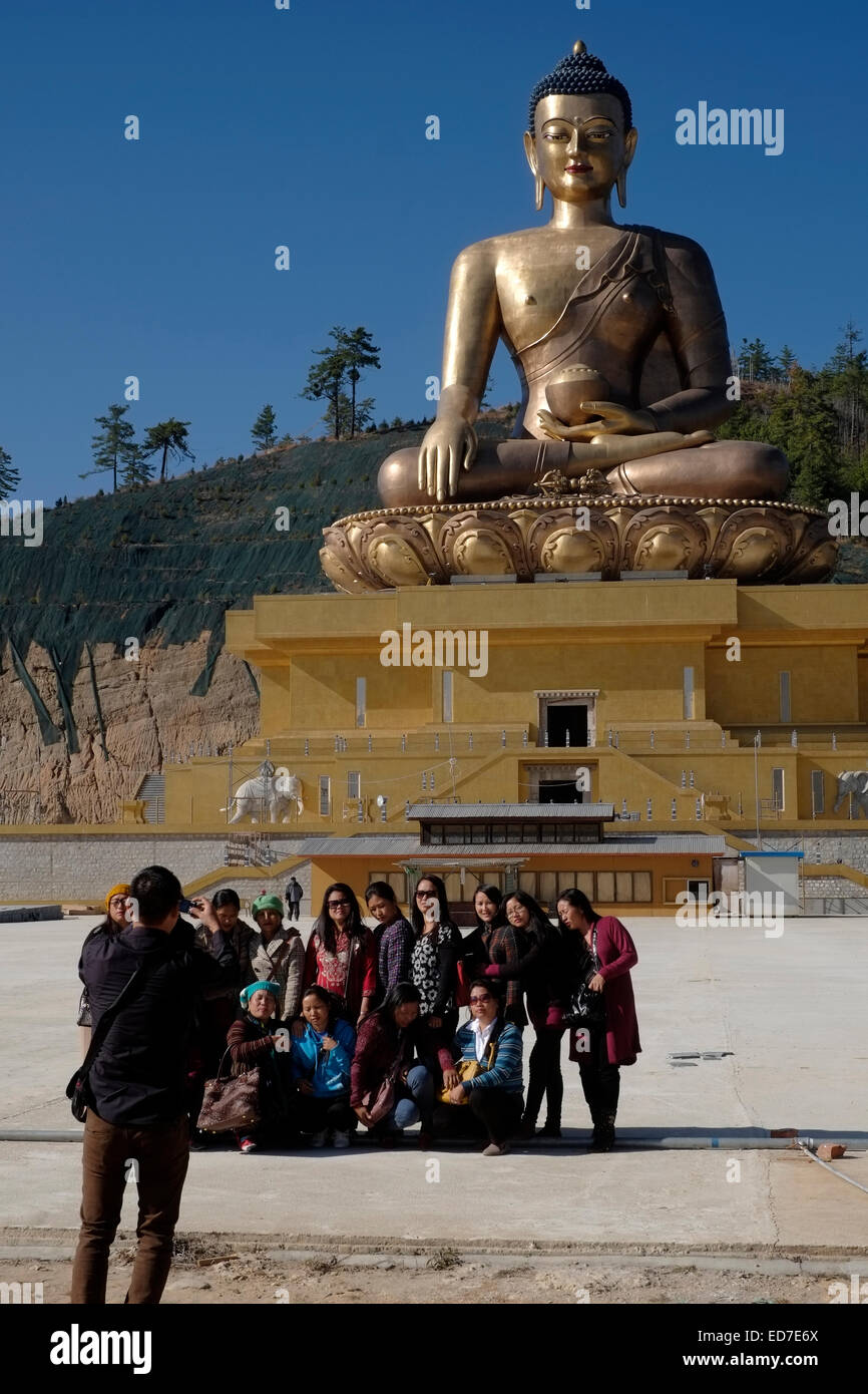 Asiatische Touristen an der gigantischen Buddha Dordenma-Statue im Bau in den Bergen nahe der Stadt von Thimphu, Bhutan am 9. Dezember 2014.  Die Gesamtkosten des Projekts Buddha Dordenma ist weit mehr als US$ 100 Millionen. Nach der Fertigstellung wird es eines der größten Buddha-Rupas in der Welt, auf einer Höhe von 169 51,5 Metern sein. Stockfoto