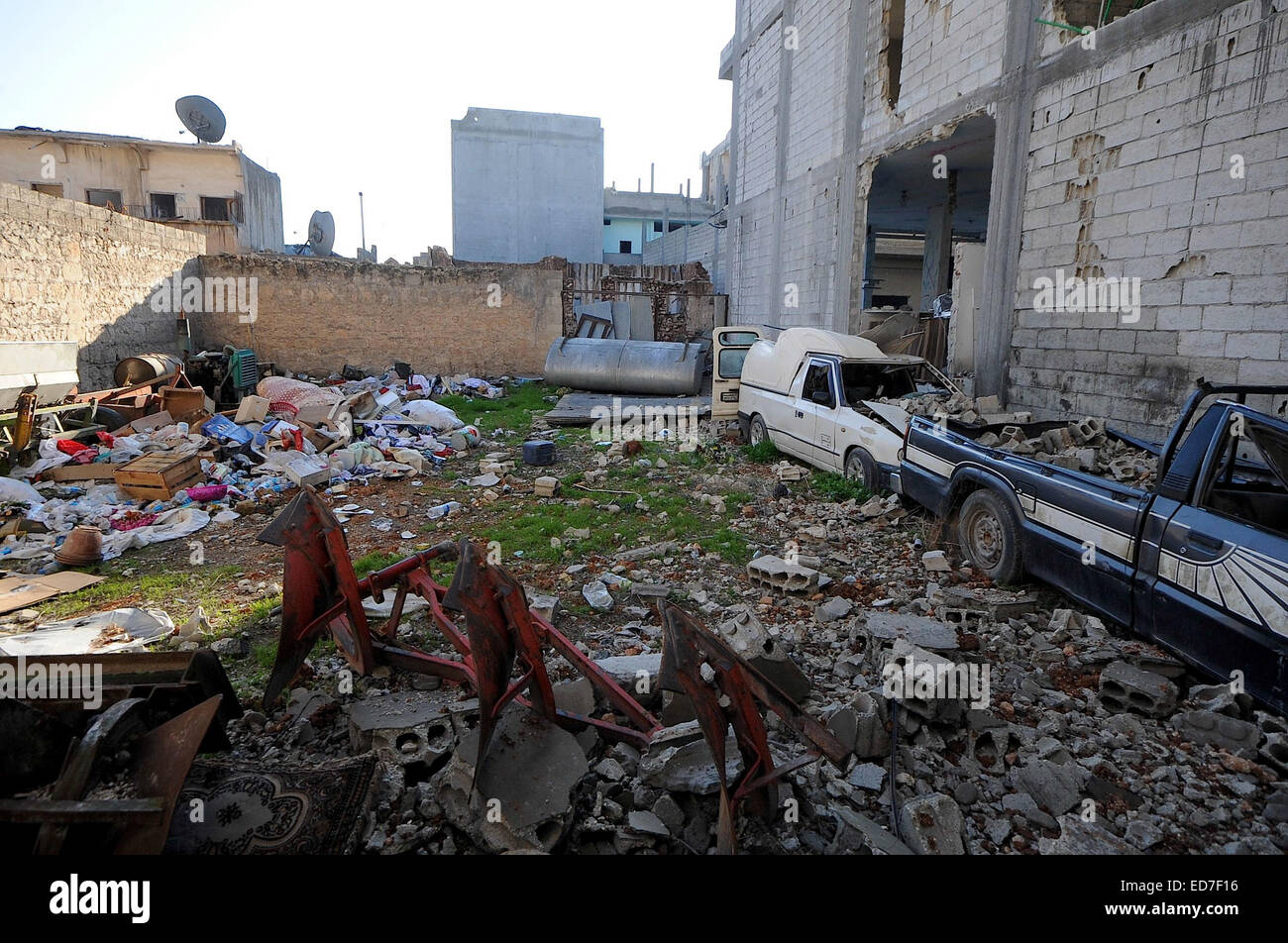 Kobane, Syrien. 21. Dezember 2014. Die kurdischen Verteidiger von Kobane nennen ihre Stadt "Stalingrad". Die Straßen sind Schutt gefüllt, zerbrochene Glas deckt den Boden überall und Scherben aus Metall und Schrapnell bedecken den Boden. Die meisten Häuser sind auf ihren Rahmen reduziert und nicht explodierte Bomben füllen die Straßen. In dieser zerstörten Stadt müssen die Überlebenden mit Handfeuerwaffen, Raketen, Sprengstoff und extrem heftigen alliierten Luftangriffen befassen. Über eine bewegen muss durchlaufen Löcher klopfte in Wänden zwischen Gebäuden oder unter Bettdecke aufgereiht über Freiflächen, die Ansicht des Scharfschützen zu behindern. In den Trümmern kleine ich Stockfoto
