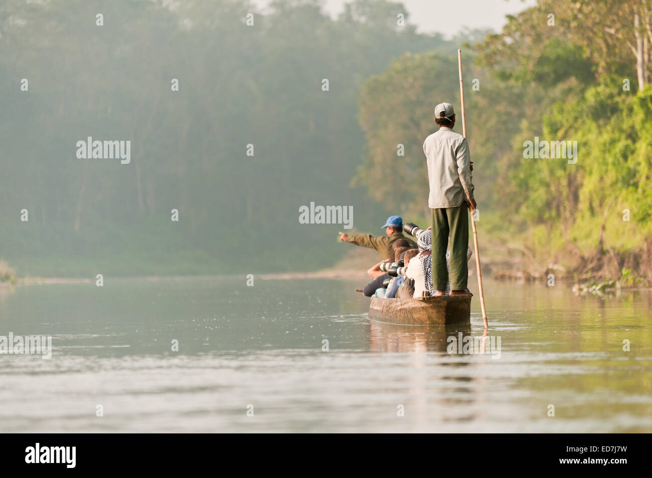 Touristen sind mit dem Ruderboot auf dem Wildfluss in Chitwan Nationalpark Nepal unterwegs. Stockfoto