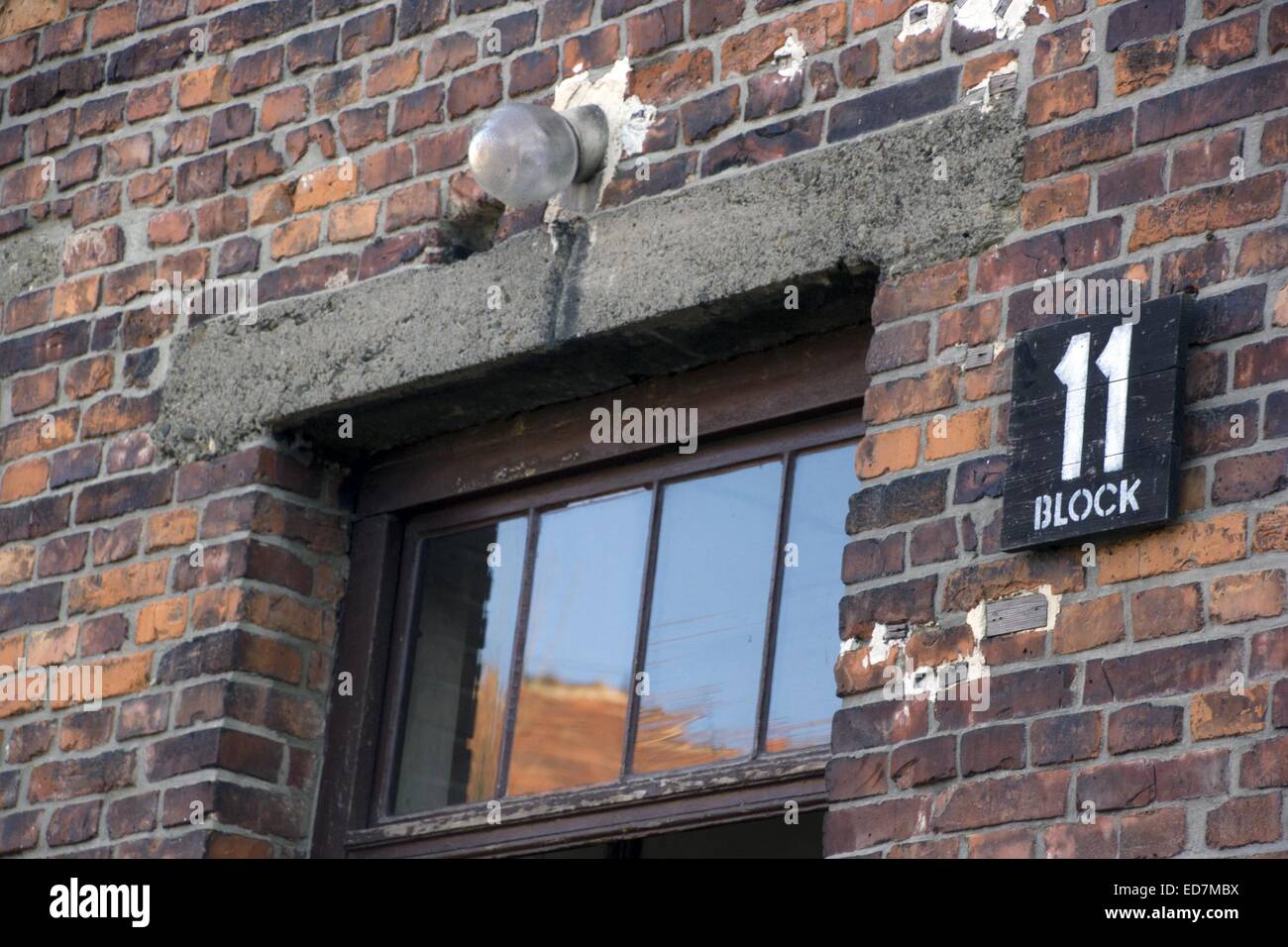 Das Zeichen neben dem Fenster zeigt "Block 11" im ehemaligen KZ Auschwitz in Oswiecim, Polen, 12. Dezember 2014. "Block 11" war der Ort der ersten Tests mit Cyclon B Gas auf Hunderte von sowjetischen Kriegsgefangenen durchgeführt. KZ Auschwitz-Birkenau wurde schließlich am 27. Januar 1945 von der sowjetischen Armee befreit. Dem Gelände des Konzentrationslagers, ein UNESCO-Weltkulturerbe ist seit 1947 ein Museum und eine Gedenkstätte Website, wurde benannt "Auschwitz-Birkenau - Deutsches Nationalsozialistisches Konzentrations-Und Vernichtungslager" (Auschwitz-Birkenau - Ge Stockfoto