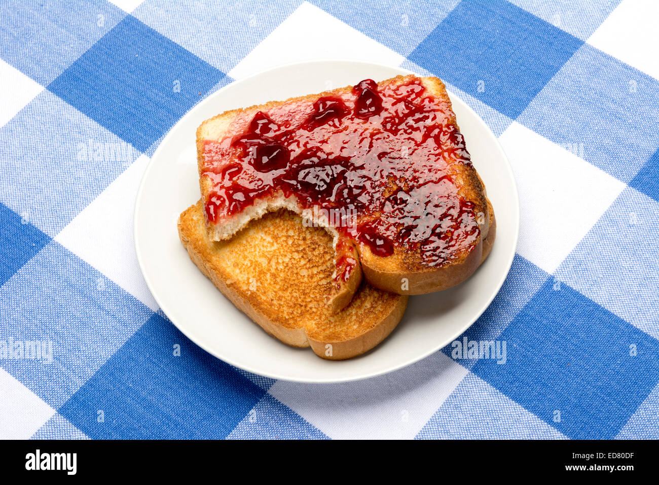 Frischen, heißen Toast mit Traubengelee verteilen sitzt mit einem Biss es während den Mahlzeiten herausgenommen. Stockfoto