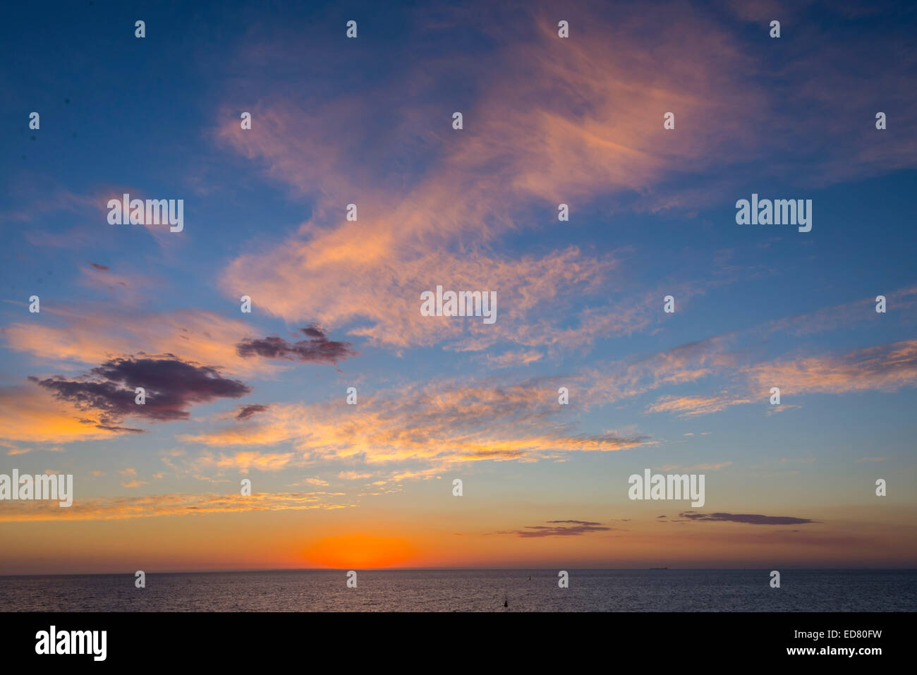 Sonnenuntergang, die helle Sonne in Blau Himmel über das Meer nur wenige launisch Wolken hervorragende Farbe Stockfoto